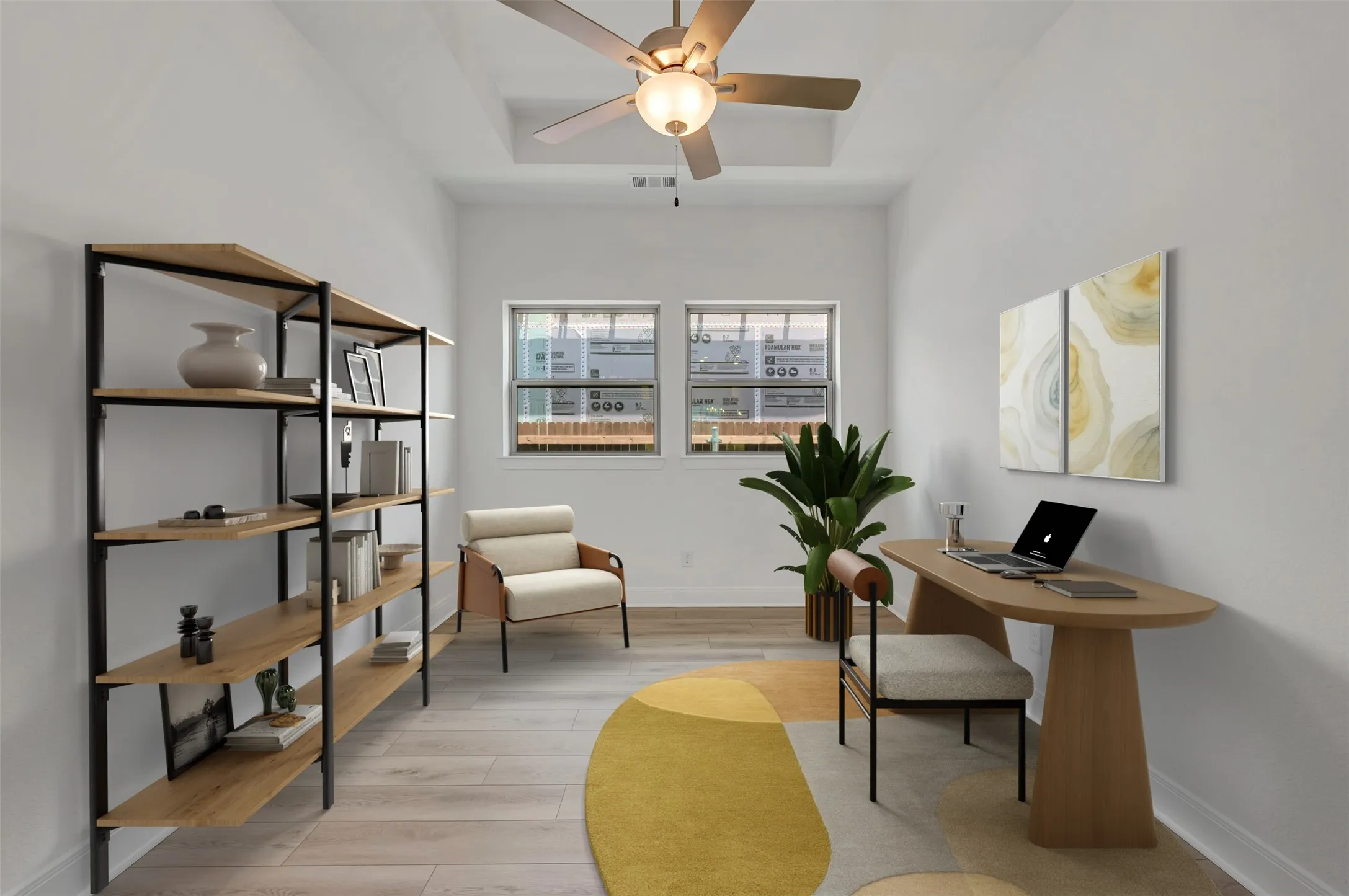 Room featuring light wood-finish flooring, white walls, and a tray ceiling with a ceiling fan