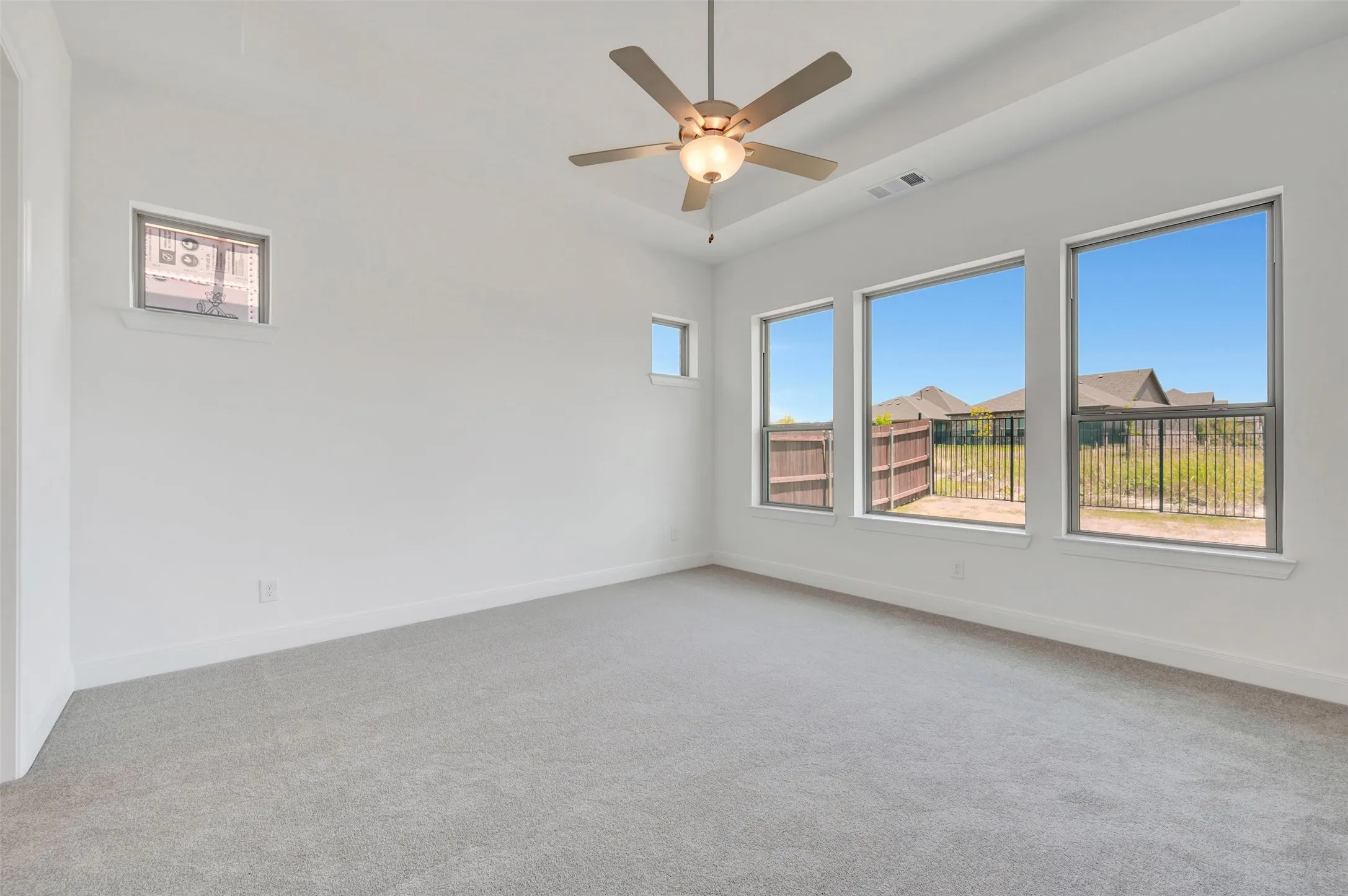 Spacious room featuring light gray carpeting and white walls