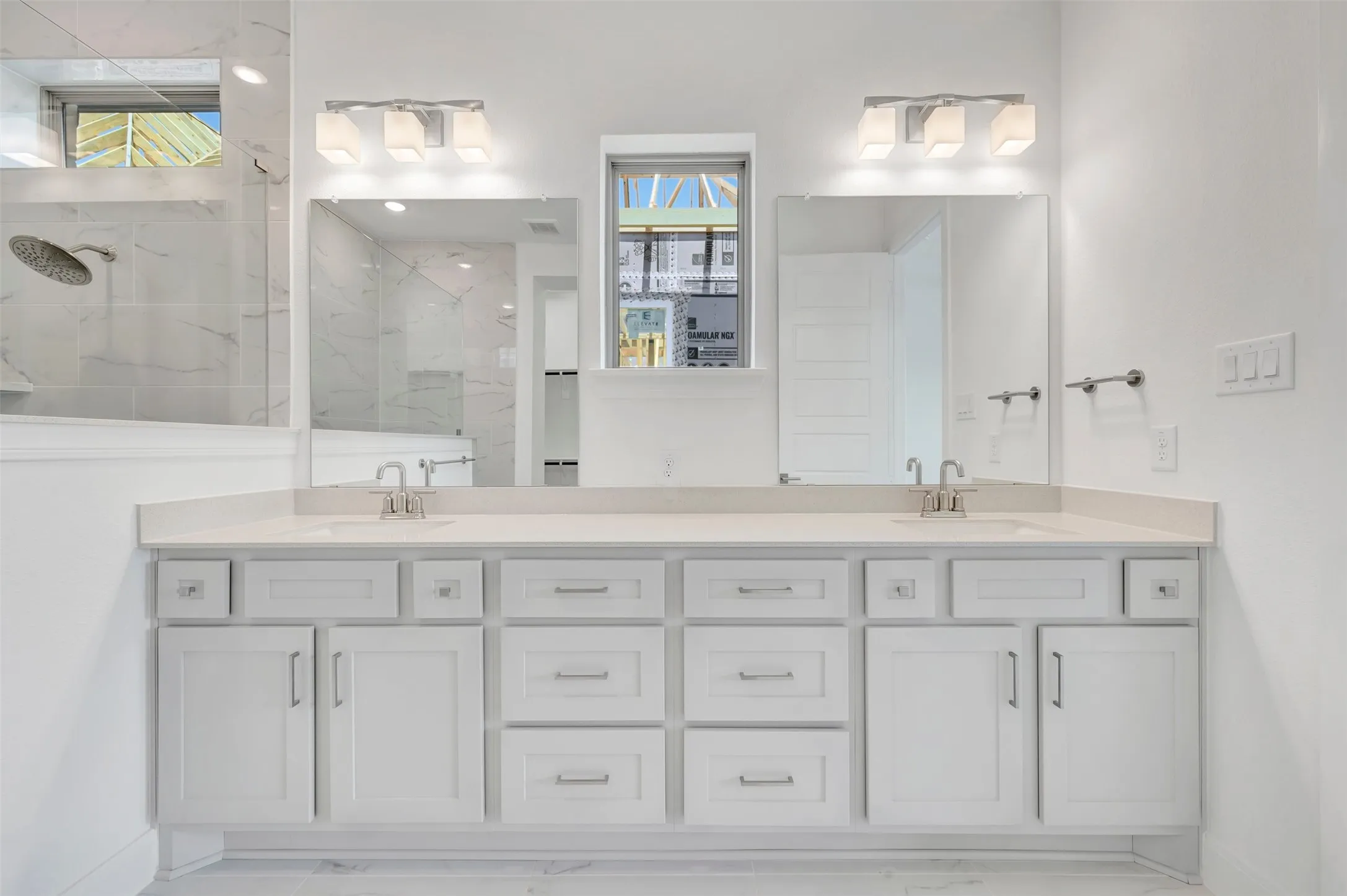Dual vanity with white cabinetry and integrated sinks set beneath individual mirrors and vanity lighting