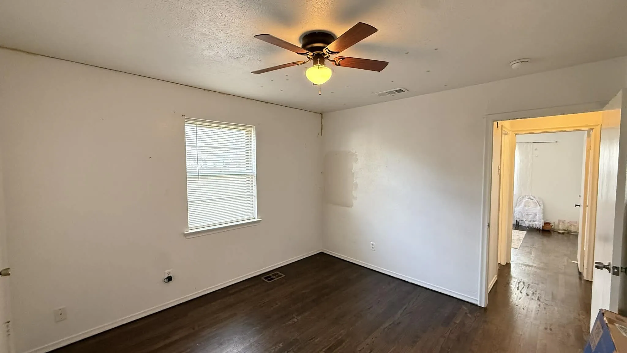 Unfurnished room with dark wood finished floors, ceiling fan, and a textured ceiling
