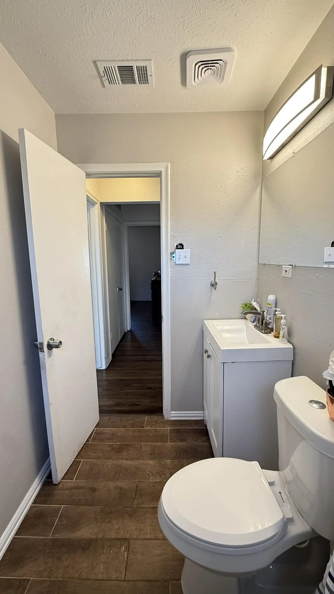 Bathroom featuring vanity, a textured ceiling, and dark wood finished floors