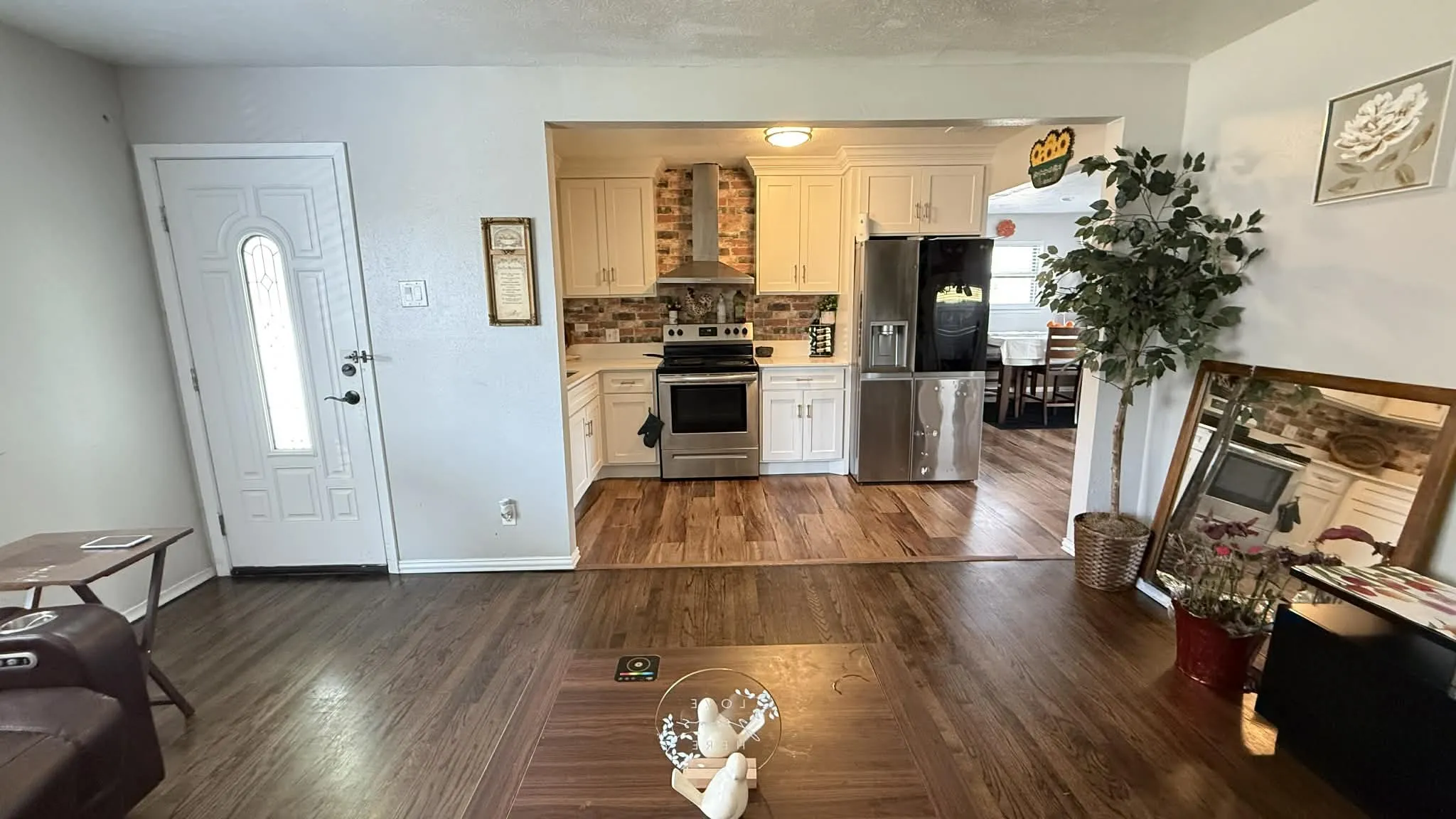 Kitchen with light countertops, stainless steel appliances, dark wood-style floors, and tasteful backsplash