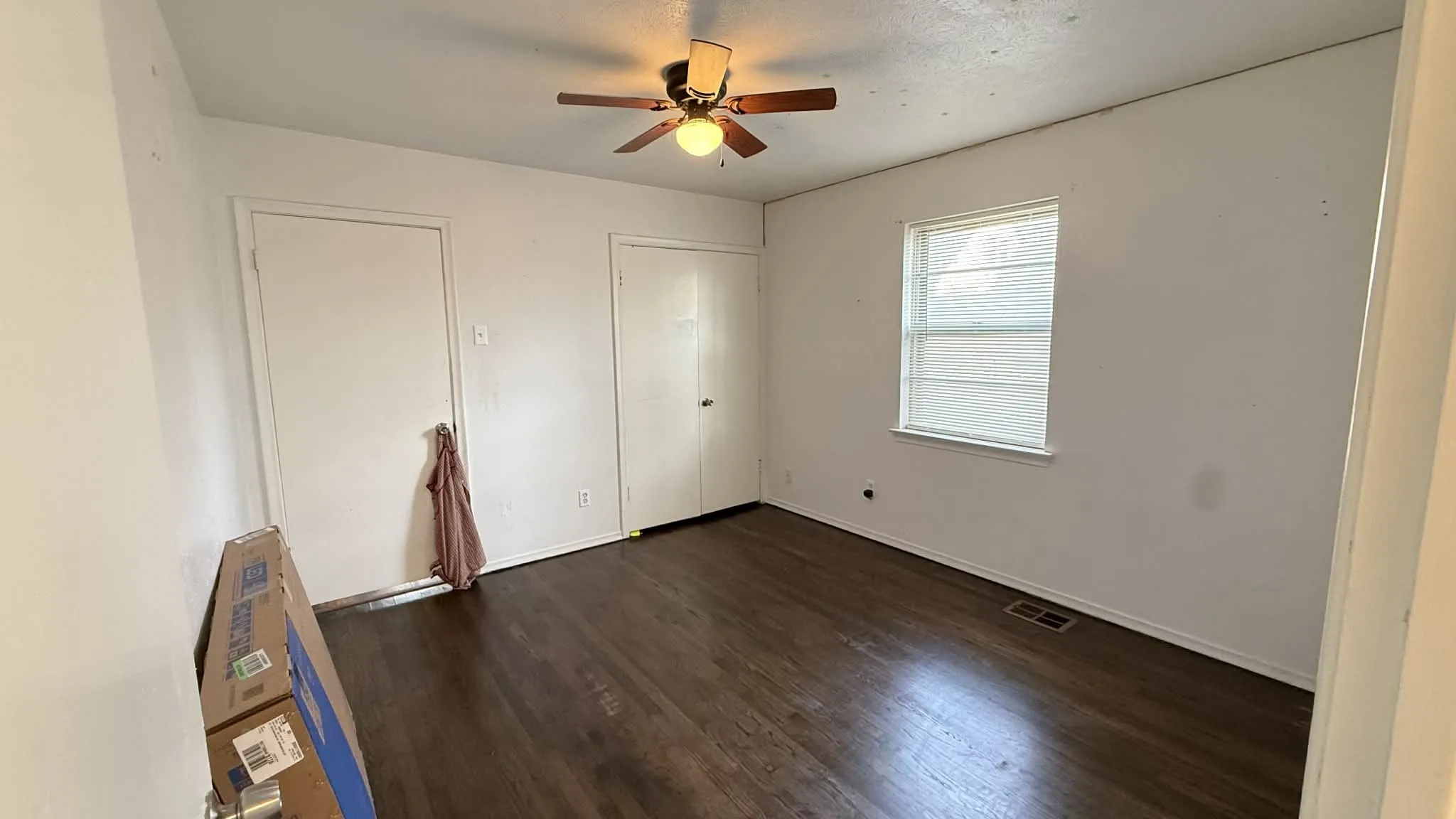 Unfurnished bedroom with dark wood-style floors and ceiling fan