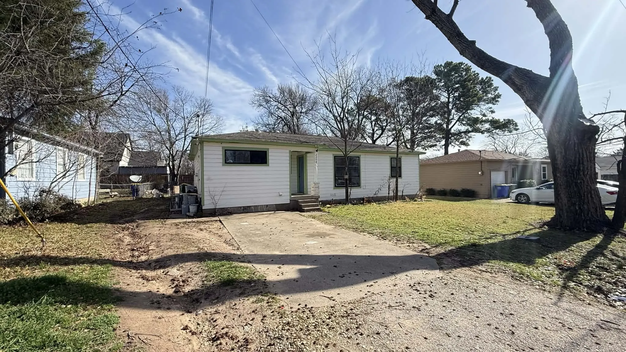 View of front of property with a front yard, entry steps, and driveway