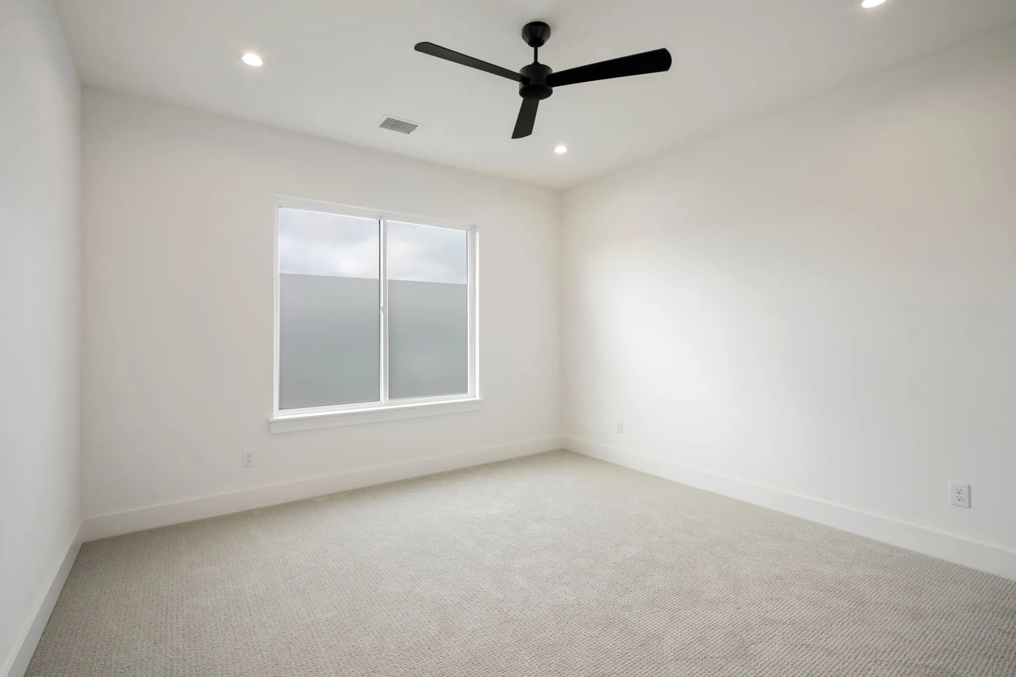 Carpeted bedroom featuring recessed lighting and a ceiling fan