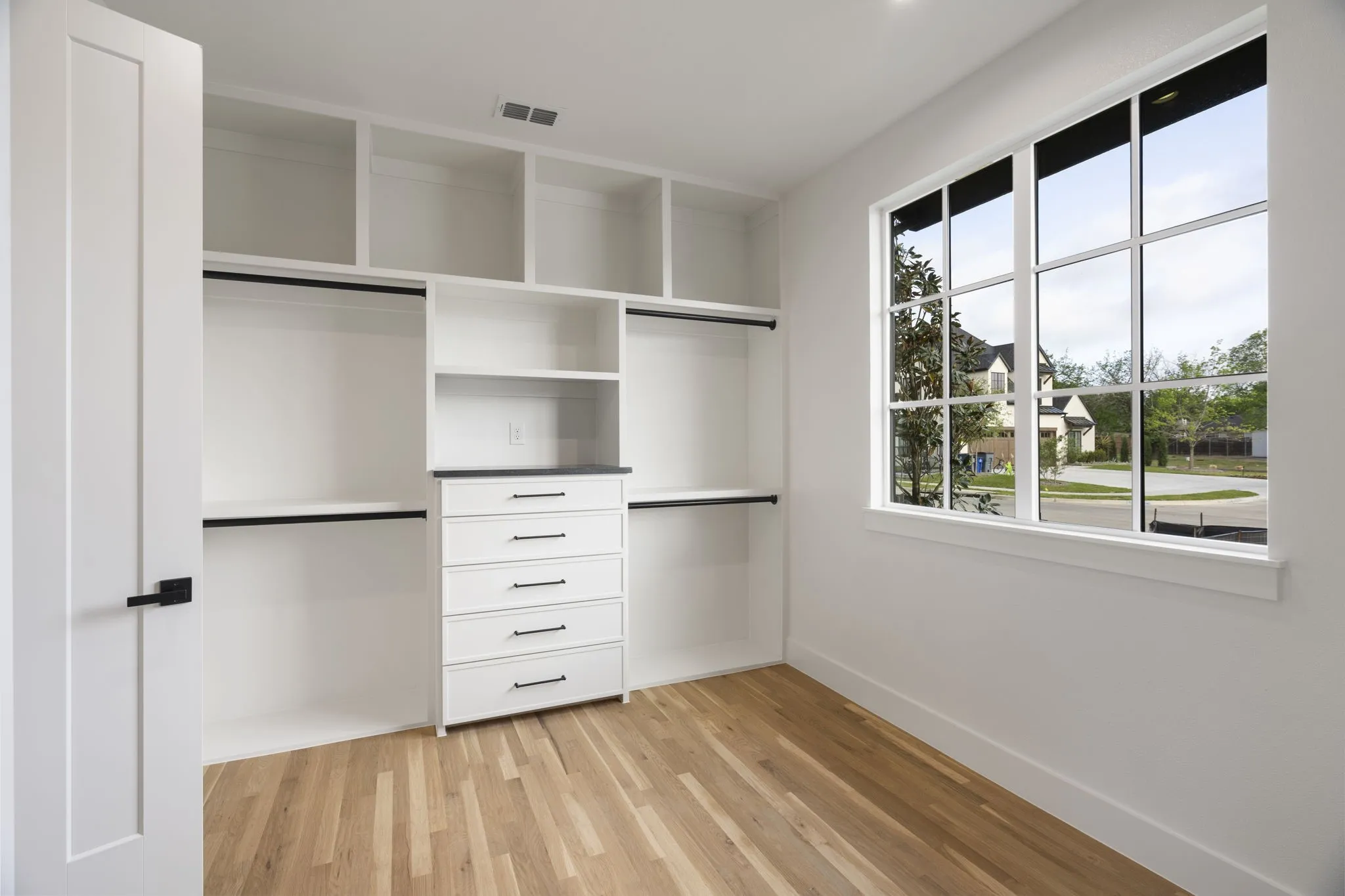 Walk in closet with light wood-type flooring