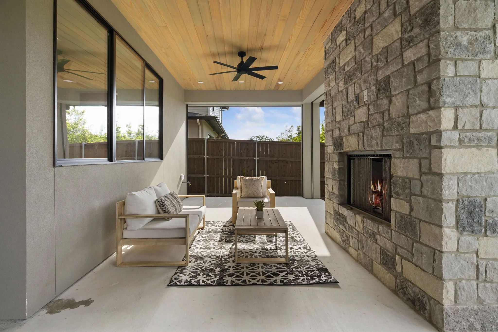 View of patio / terrace with ceiling fan and an outdoor stone fireplace