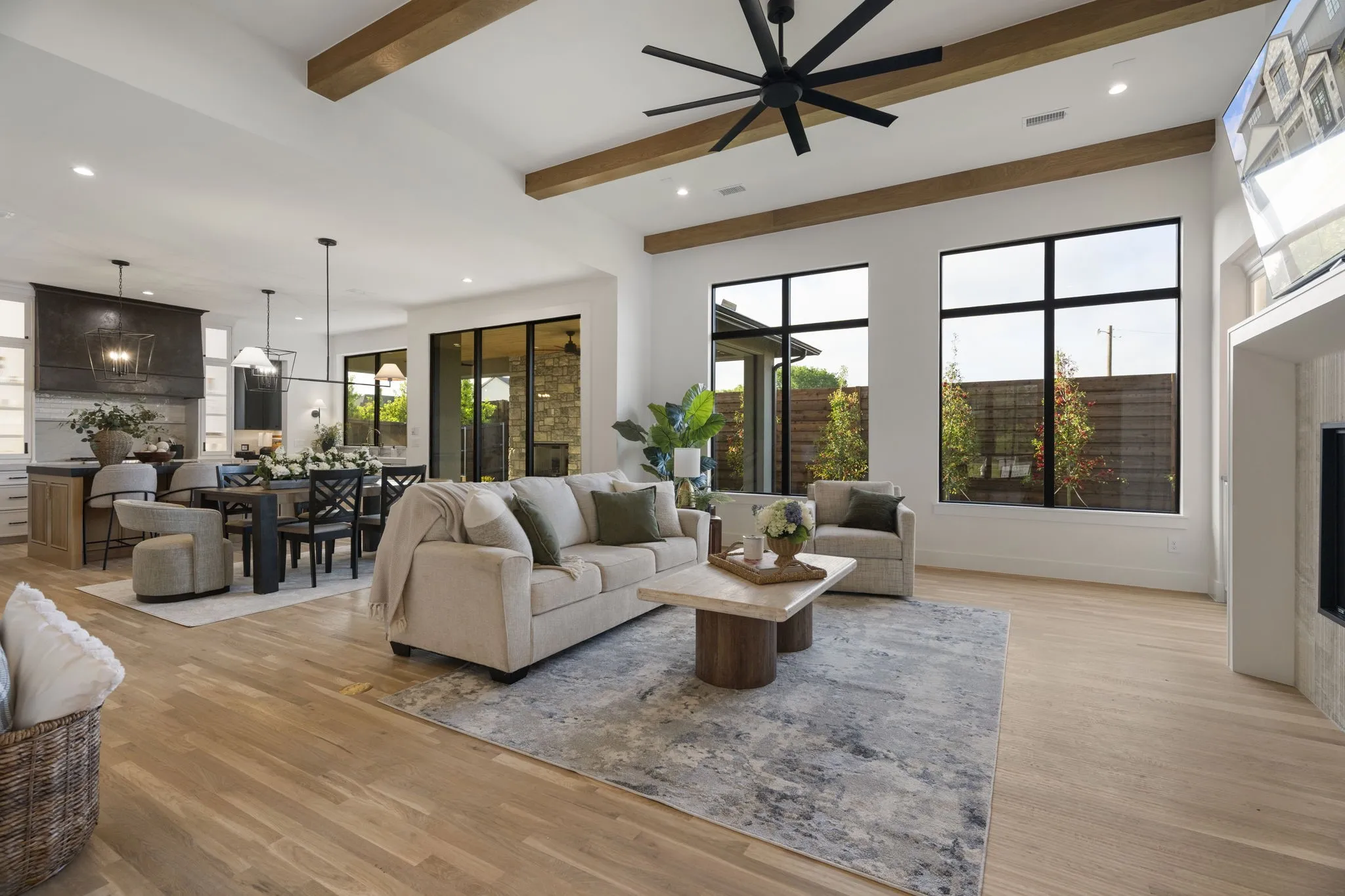 Living area with a fireplace, beamed ceiling, light wood-type flooring, recessed lighting, and ceiling fan