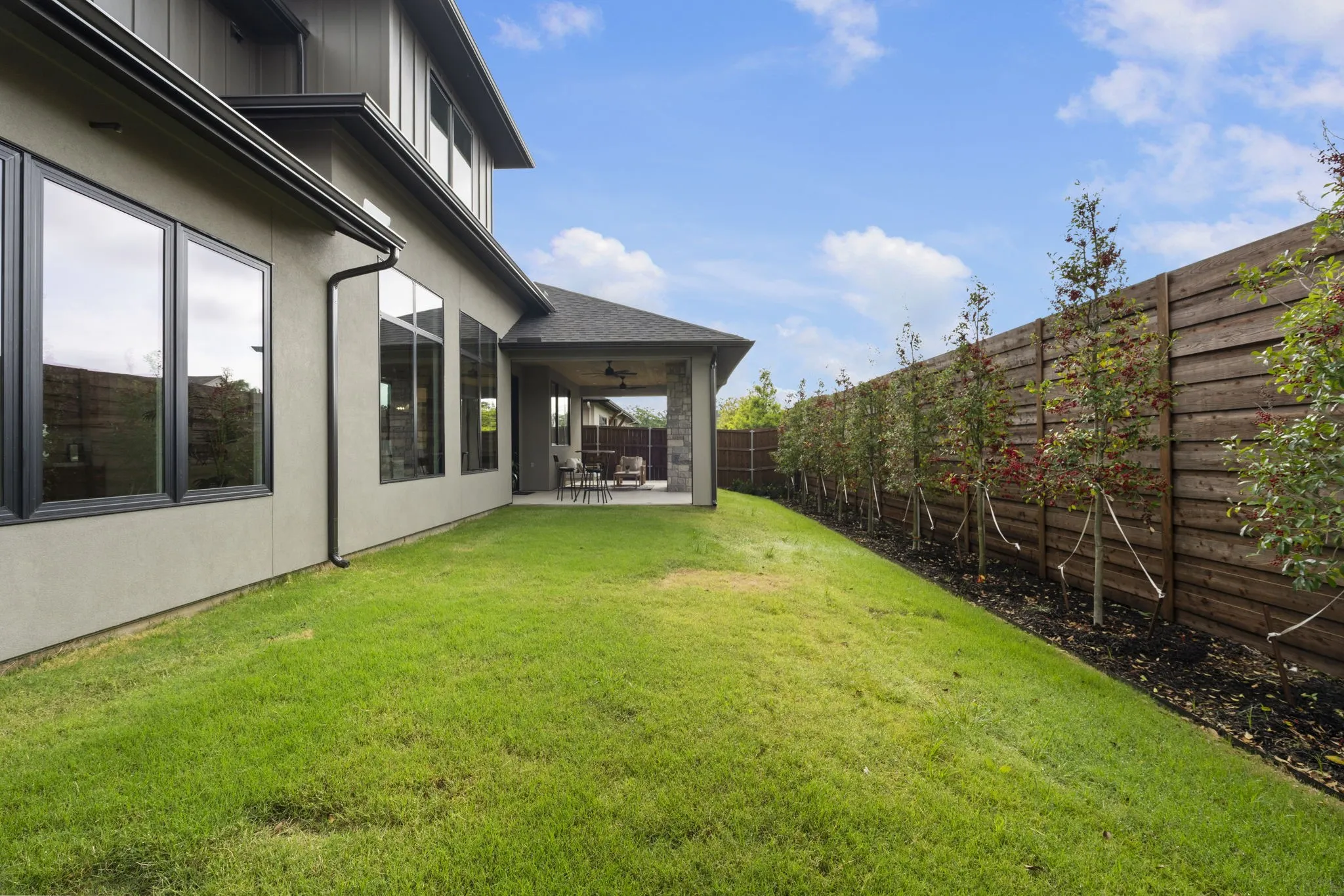 Fenced backyard featuring a fully enclosed patio area and yard fit for a pool