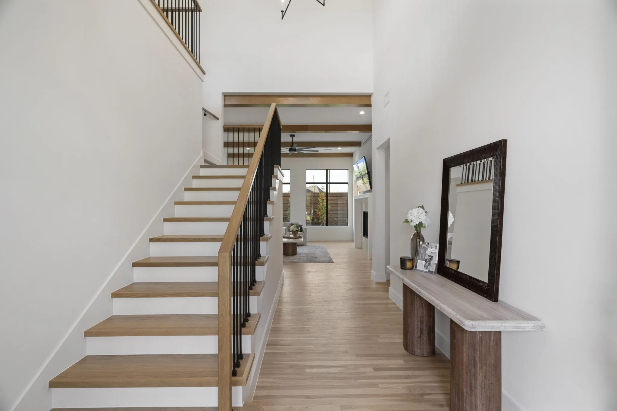Stairway featuring wood finished floors, a high ceiling, and ceiling fan