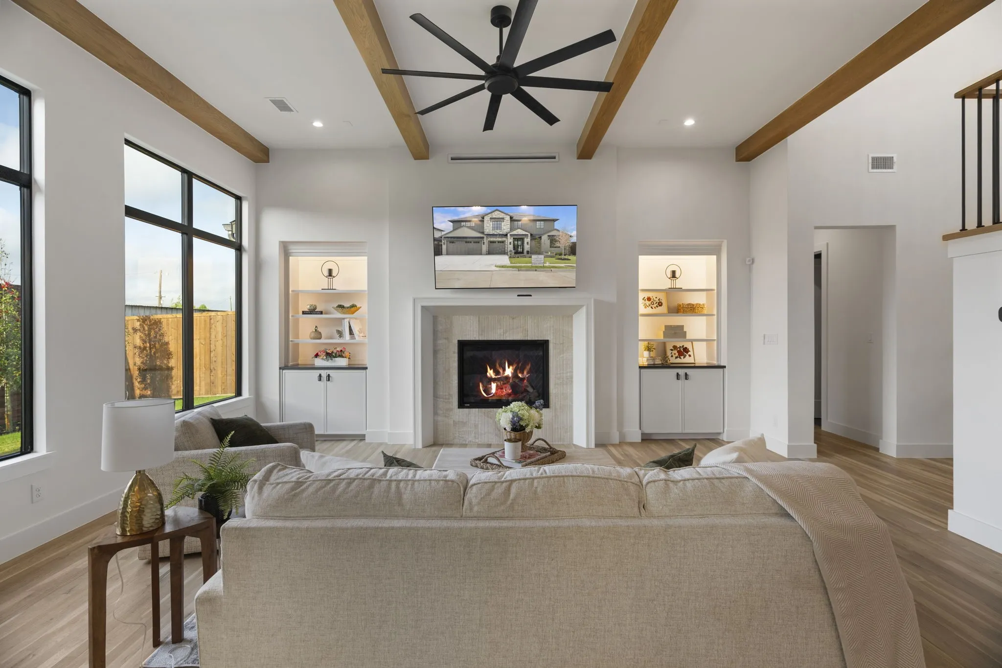 Living area featuring a ceiling fan, a tile fireplace, light wood finished floors, recessed lighting, and beamed ceiling