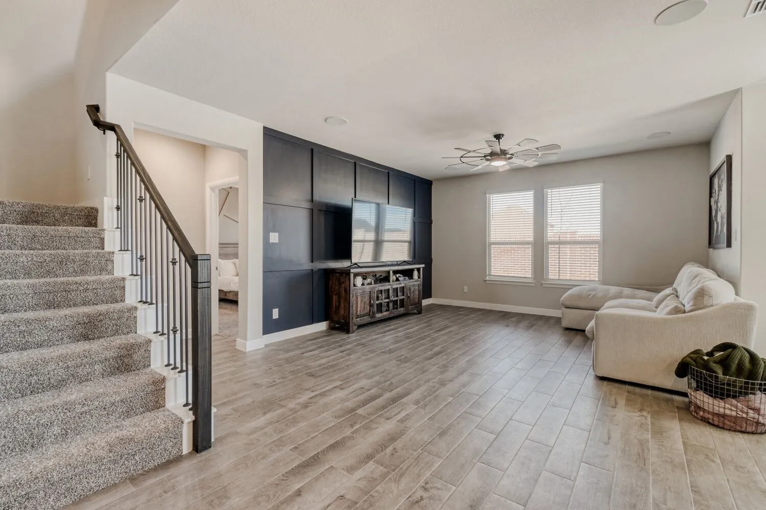 Living room featuring a ceiling fan and light wood-style floors