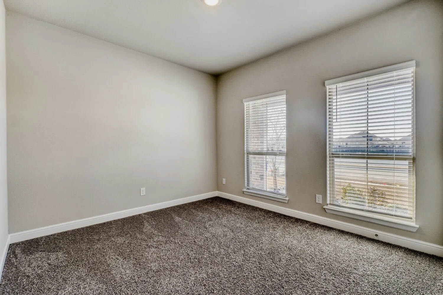 Carpeted spare room with baseboards