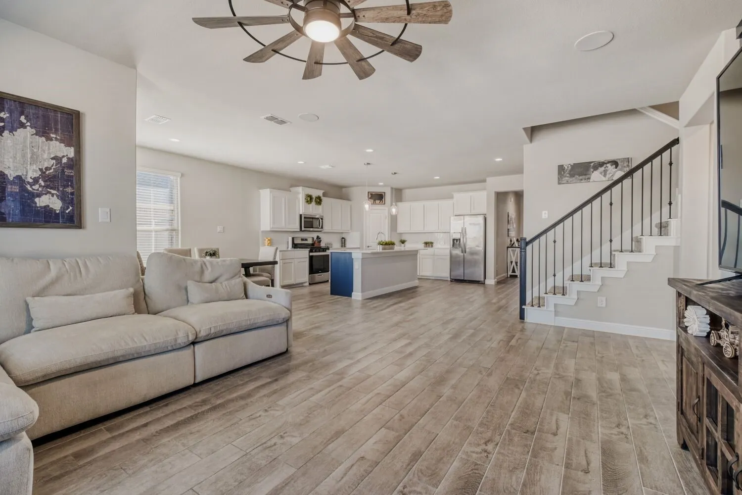 Living room with ceiling fan, light wood-style flooring, and recessed lighting