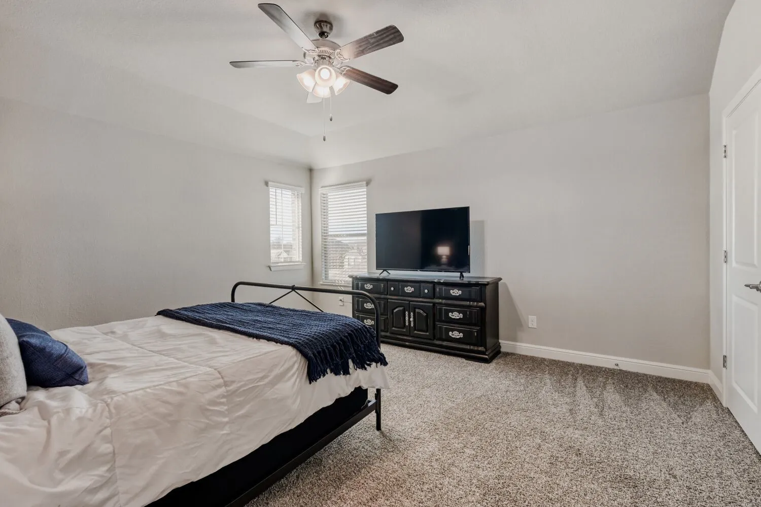 Bedroom featuring light colored carpet and a ceiling fan