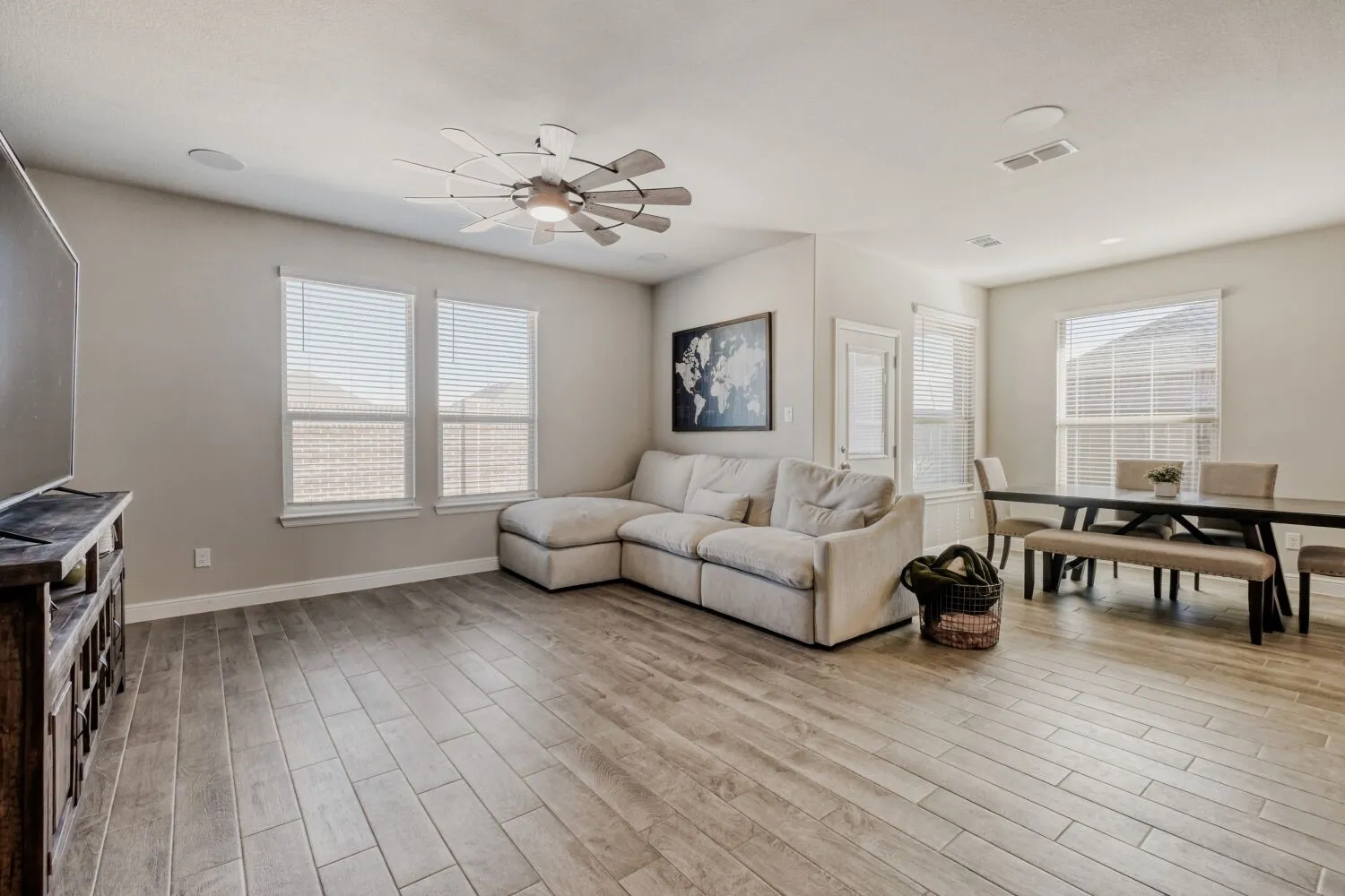 Living room featuring a ceiling fan, light wood-style floors, and healthy amount of natural light