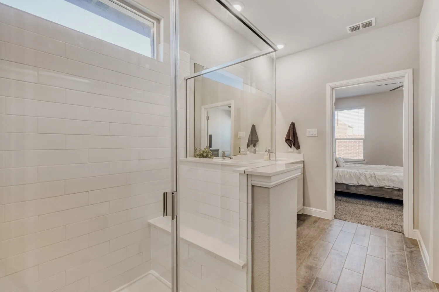 Ensuite bathroom featuring plenty of natural light, wood tiled floors, and a shower stall