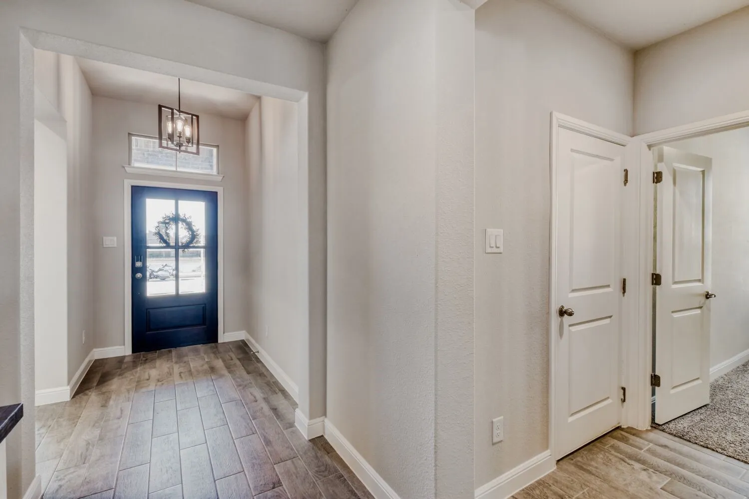 Foyer entrance featuring wood tiled floors and suspended lighting