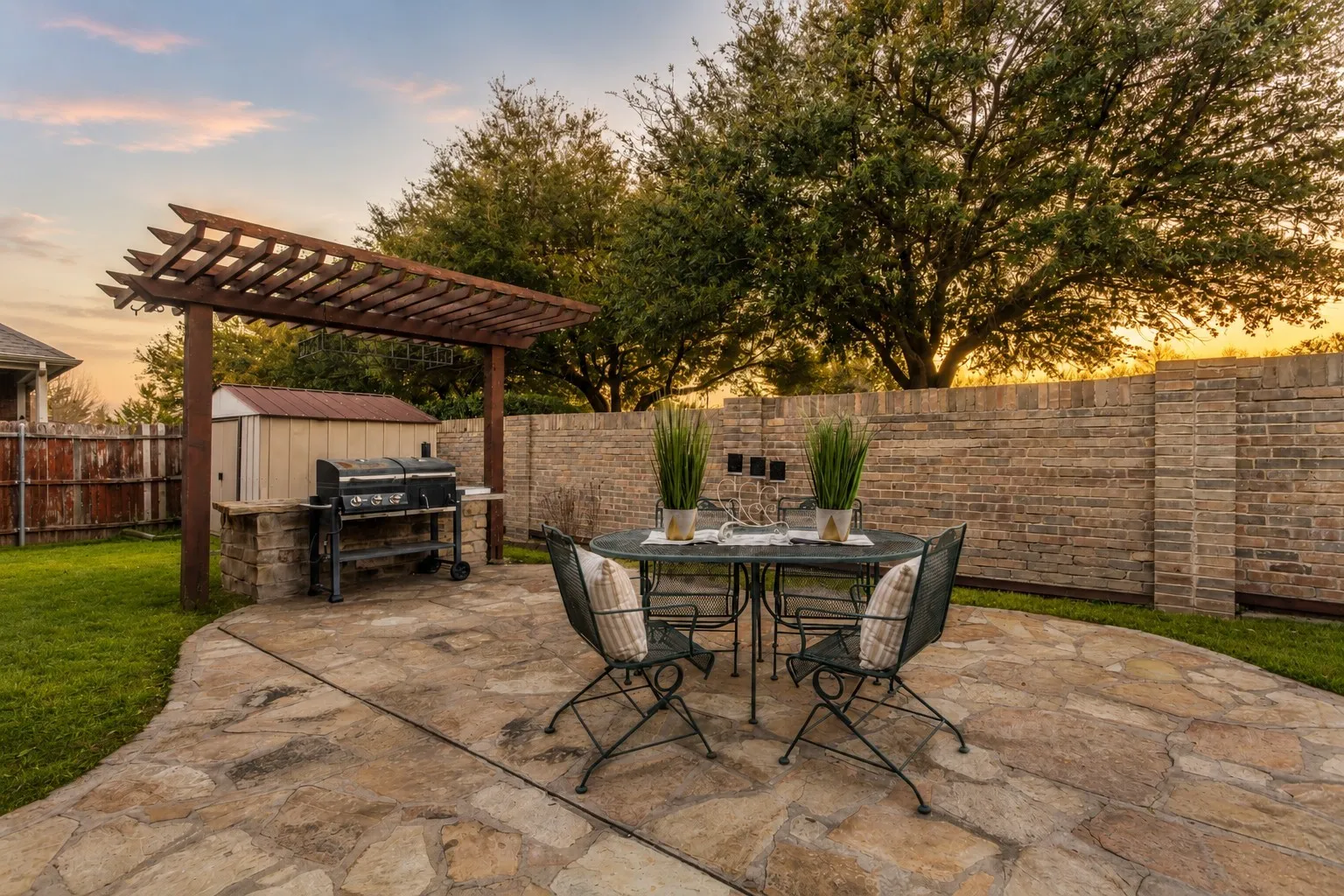 Beautiful flagstone accents enhance the backyard patio, where outdoor dining and relaxing feel like a natural extension of the interior living space. This sunset sky has been enhanced.