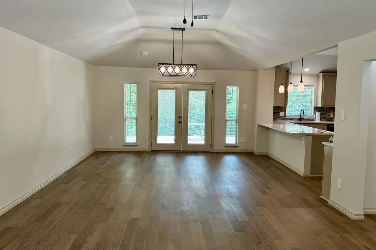 Dining room with double doors and windows overlooking back yard