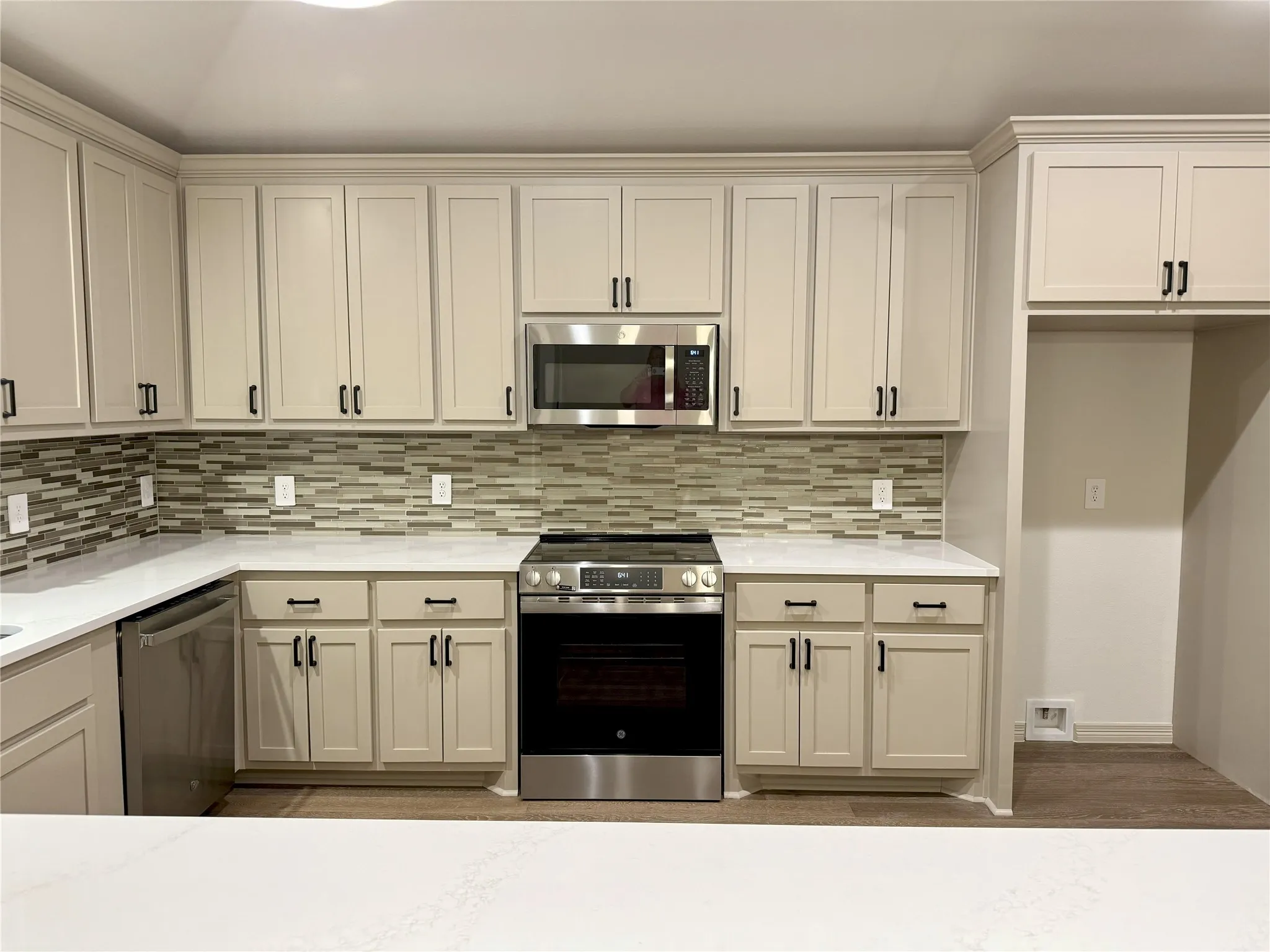 Kitchen with appliances with stainless steel finishes, light countertops, and decorative backsplash