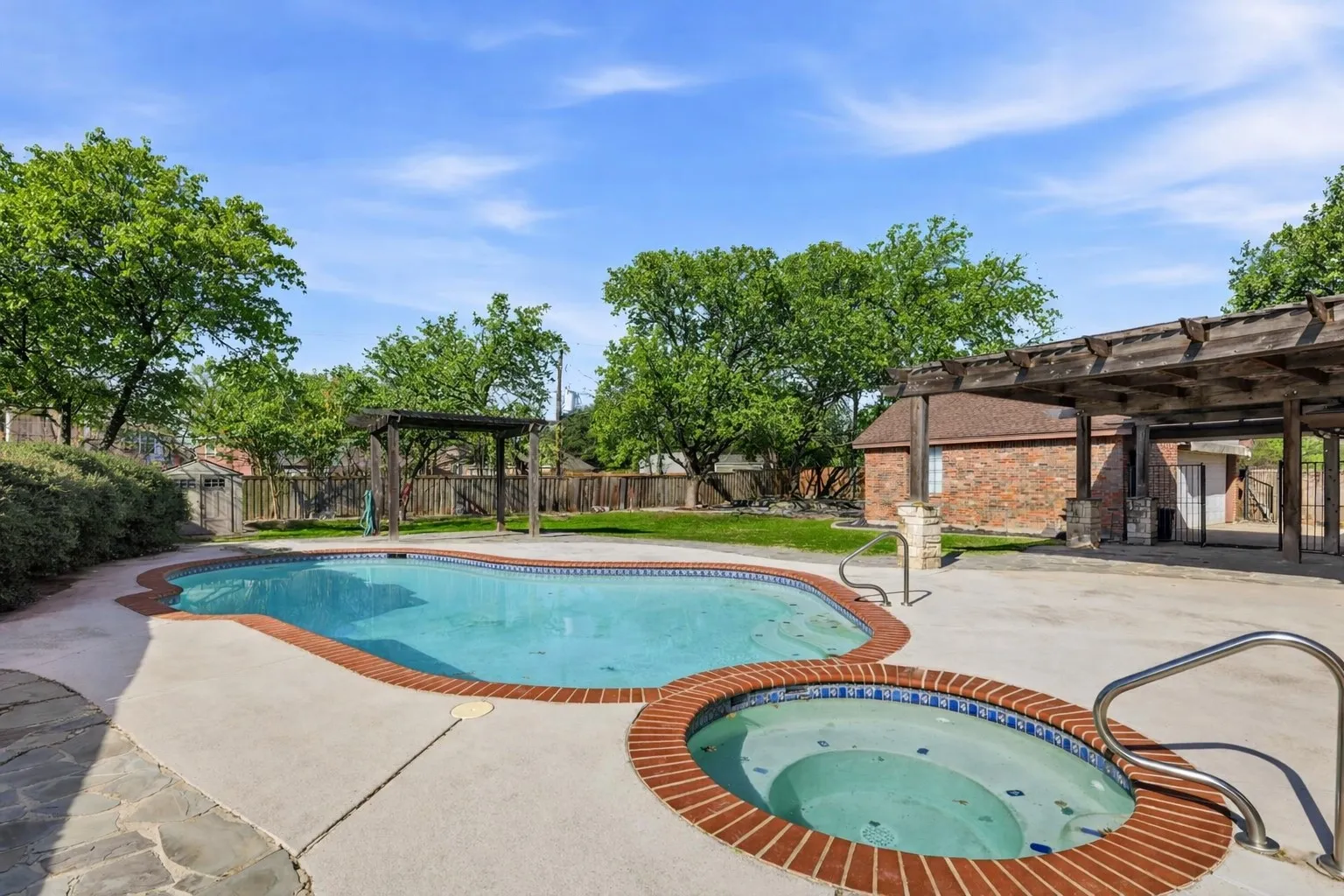 View of swimming pool featuring a pergola, patio surround, an in-ground hot tub, and a fenced backyard