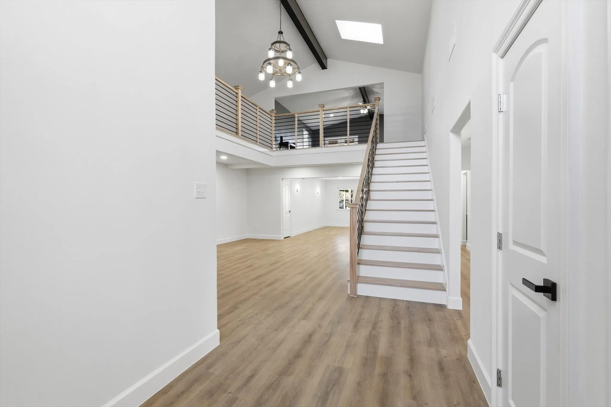 Foyer with light wood-style floors and a chandelier