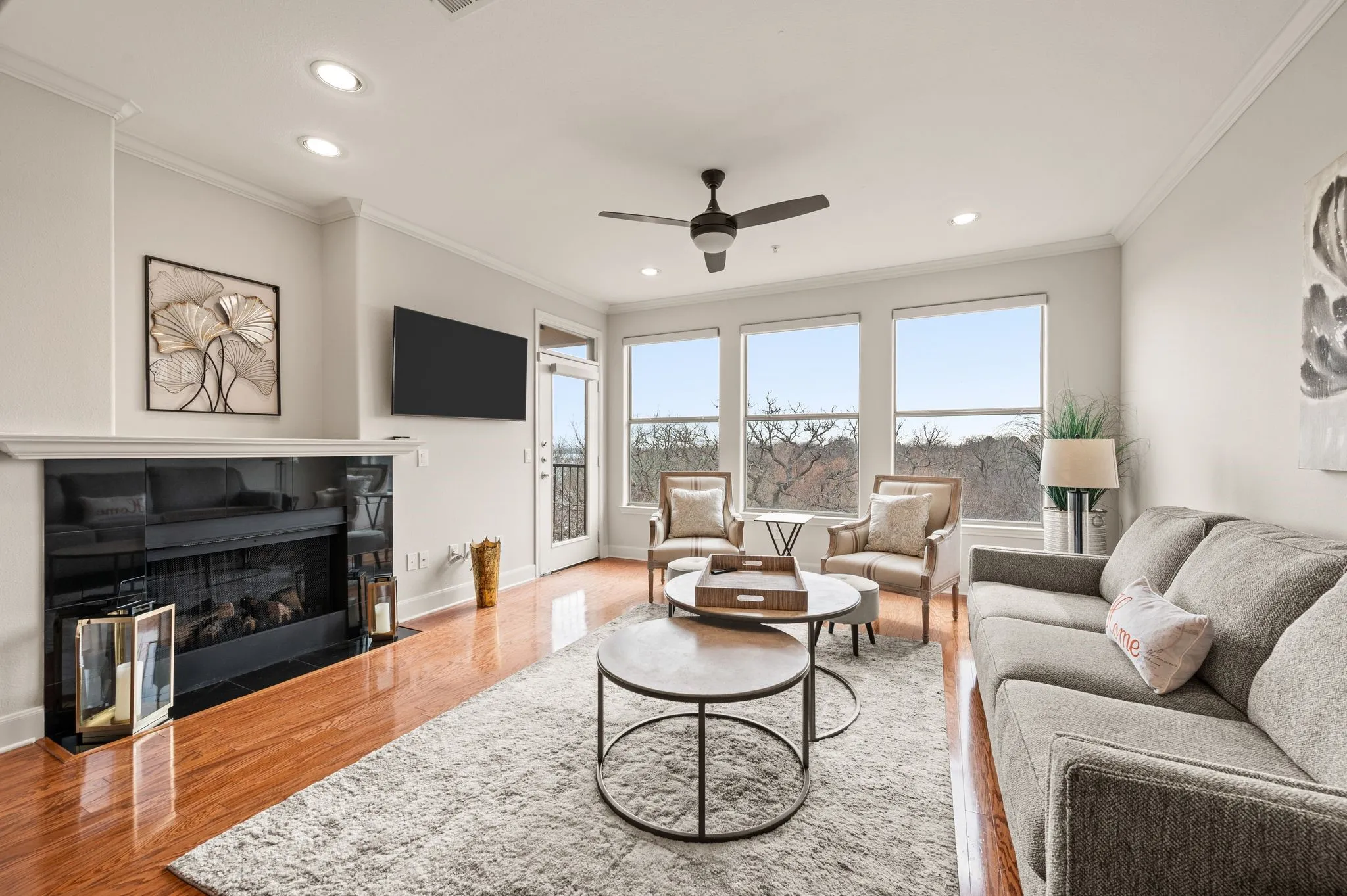 Living area with ornamental molding, a ceiling fan, wood finished floors, recessed lighting, and a fireplace with flush hearth