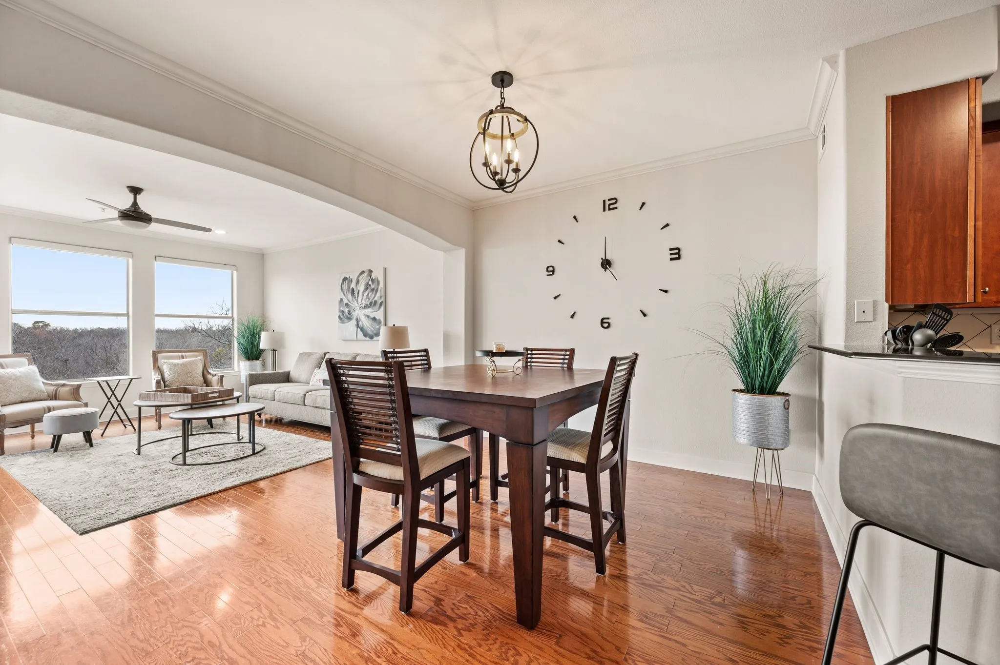 Dining room featuring light wood finished floors, ornamental molding, a ceiling fan, arched walkways, and a chandelier