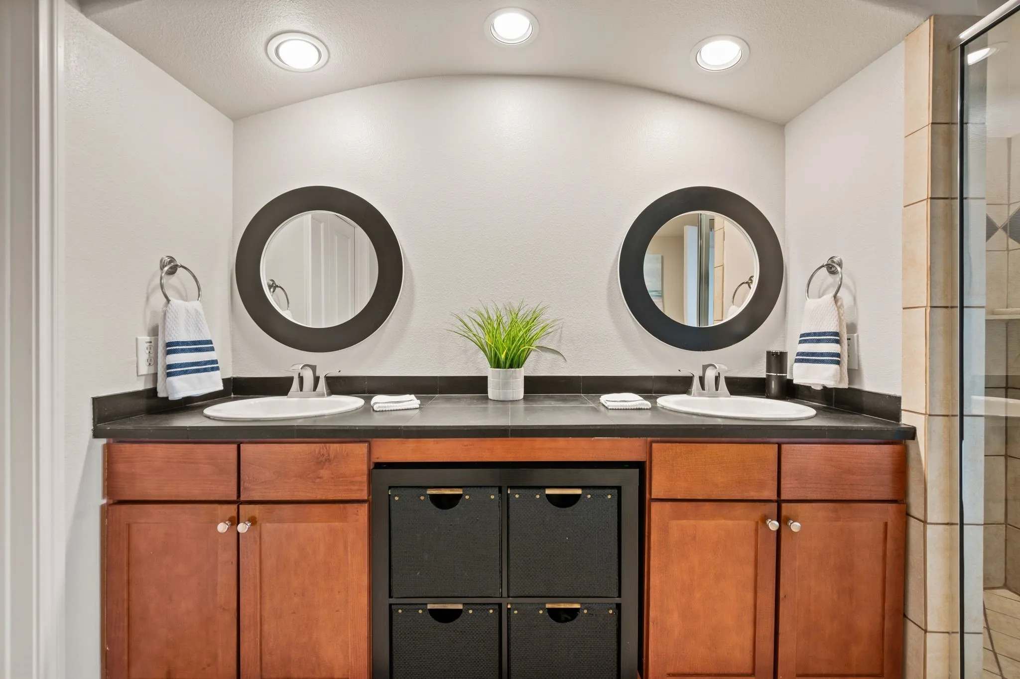 Primary bath with double vanity, recessed lighting, and a tile shower