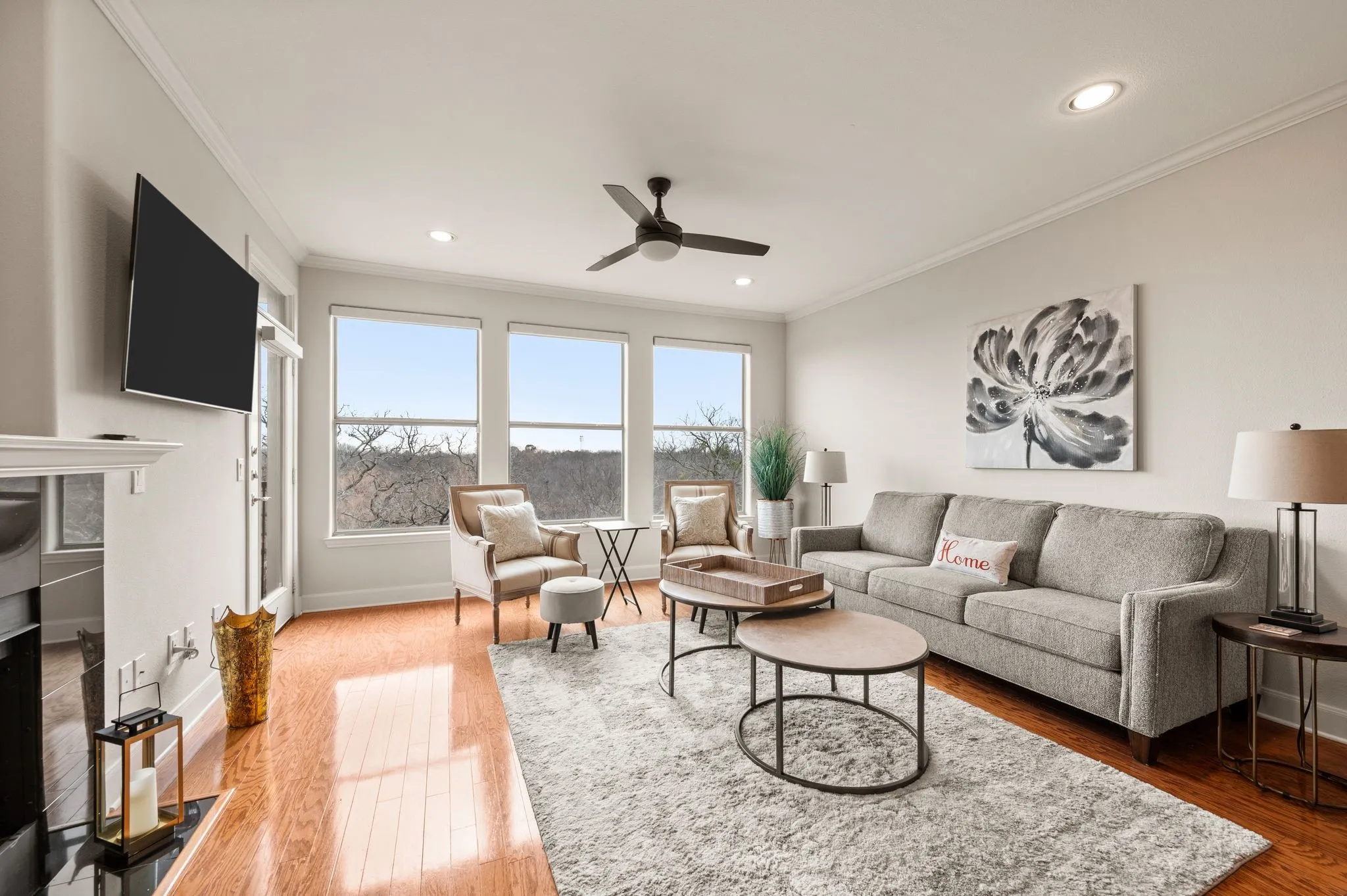 Living area with wood-type flooring, a fireplace, a ceiling fan, ornamental molding, and recessed lighting