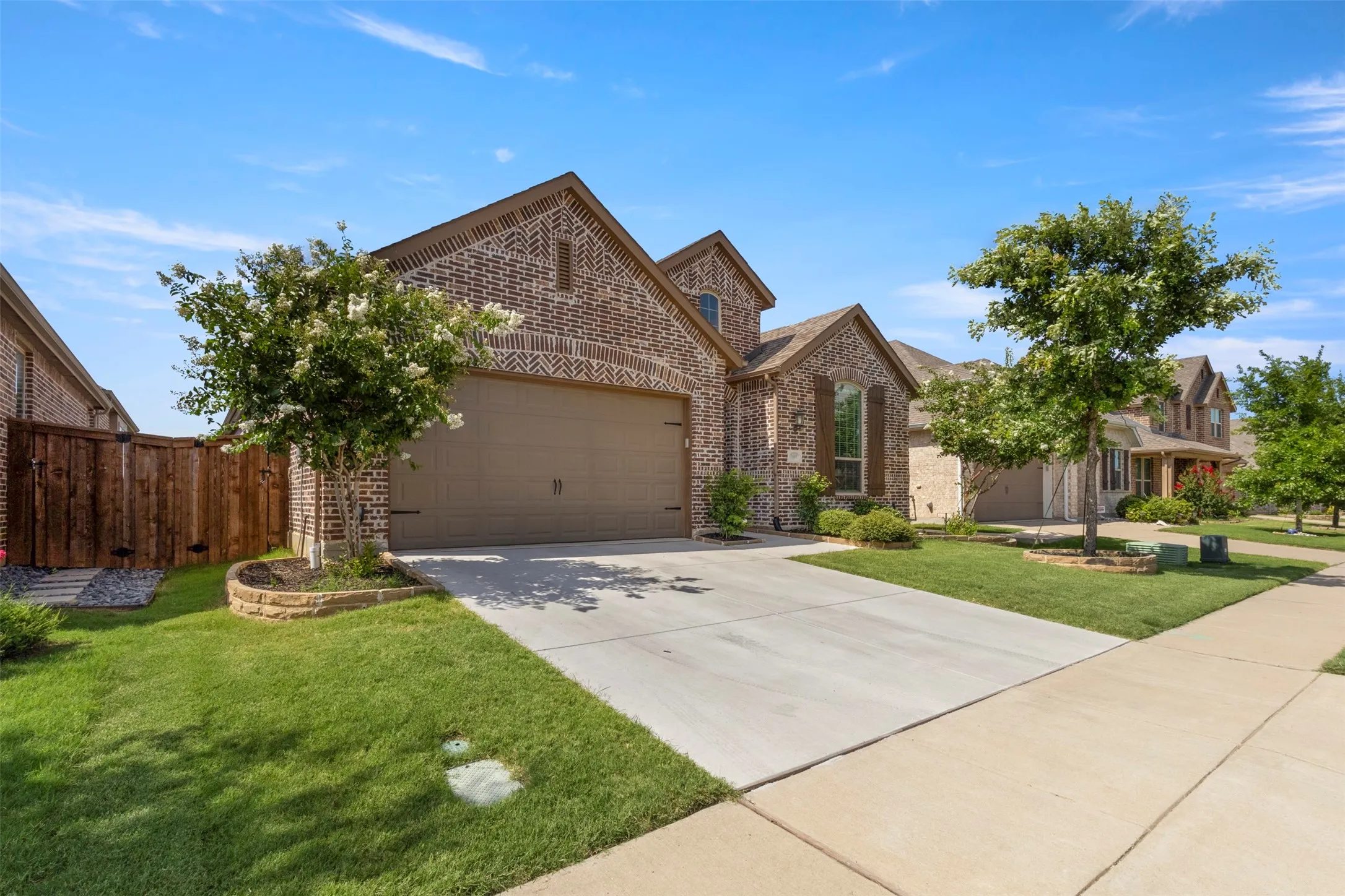 View of front of home with brick siding, a garage, and concrete driveway