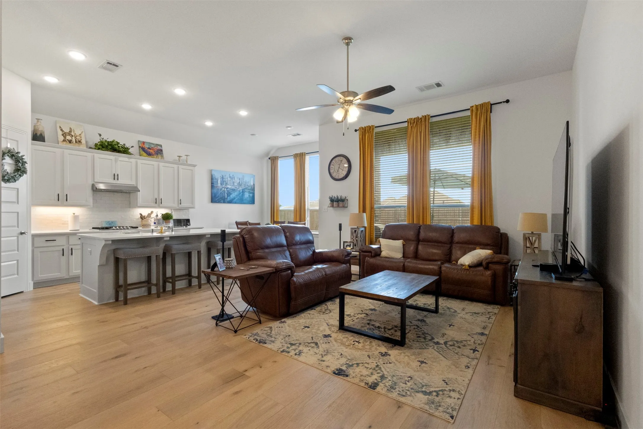 Living room and kitchen with abundant light from the windows overlooking the extended backyard