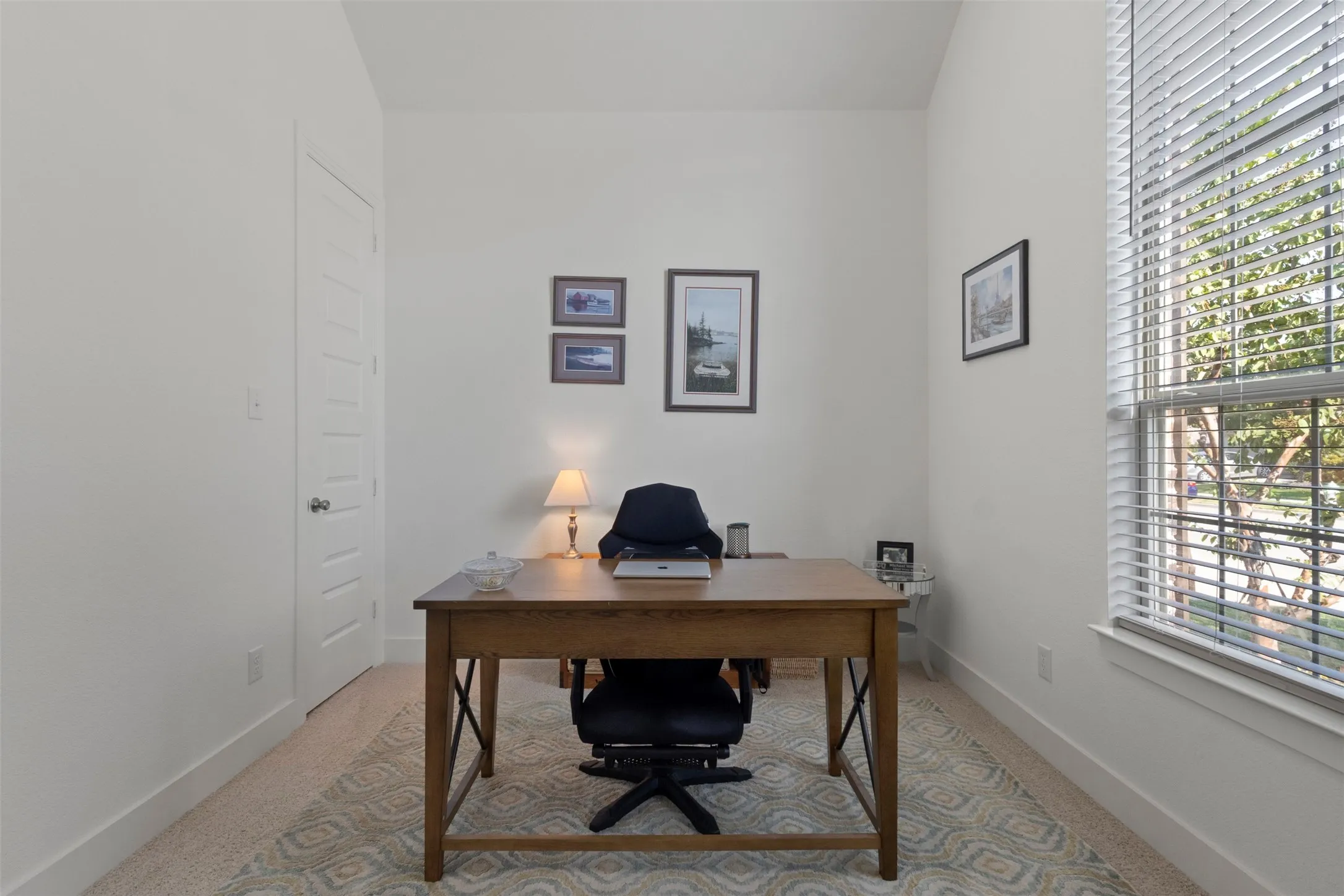 Recessed panel interior door, neutral wall paint, and a large window with horizontal blinds