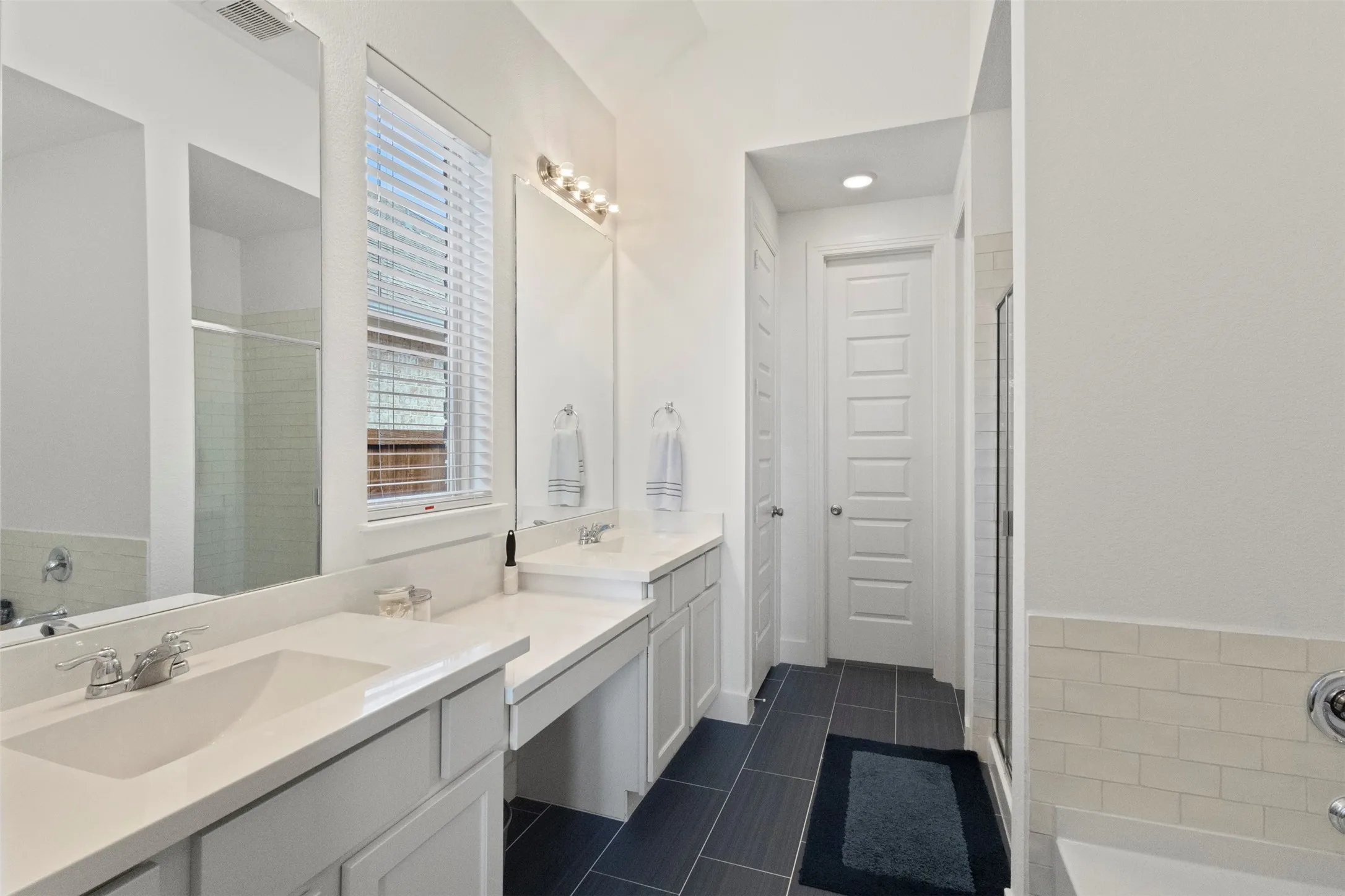 Full bath featuring vanity, a stall shower, tile patterned flooring, and a bath