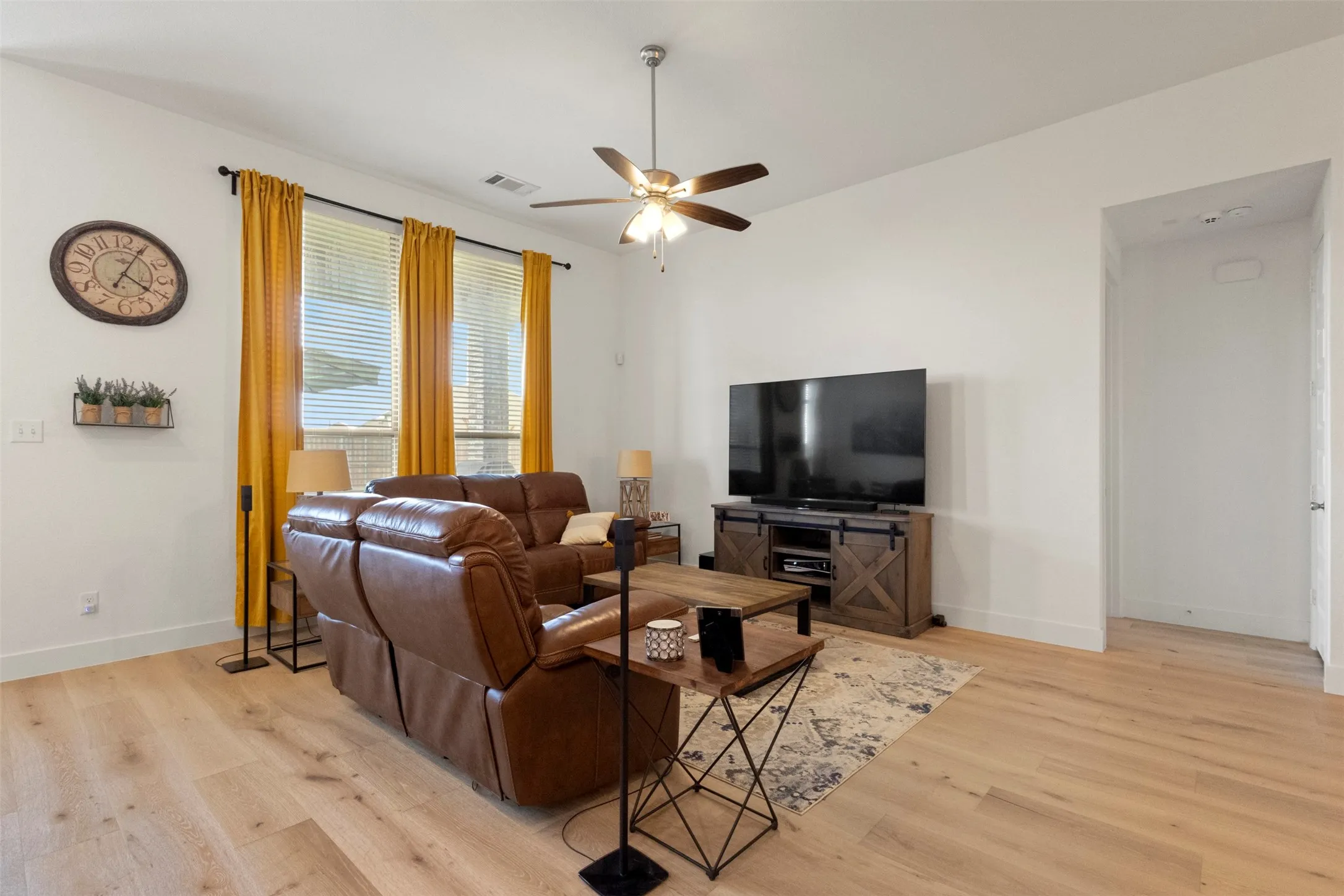 Living area with light wood-type flooring and ceiling fan