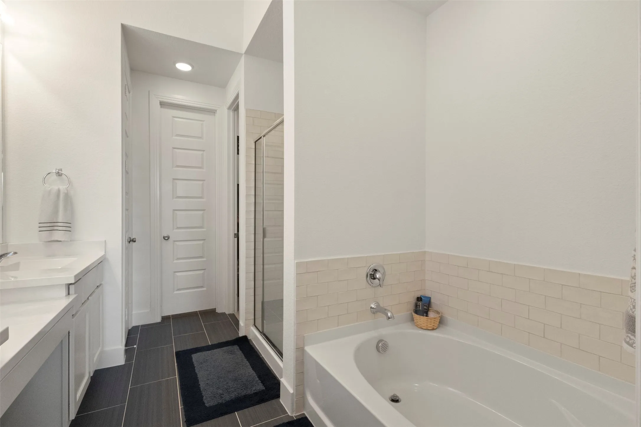 Full bathroom featuring a bath, double vanity, a stall shower, tile patterned floors, and recessed lighting