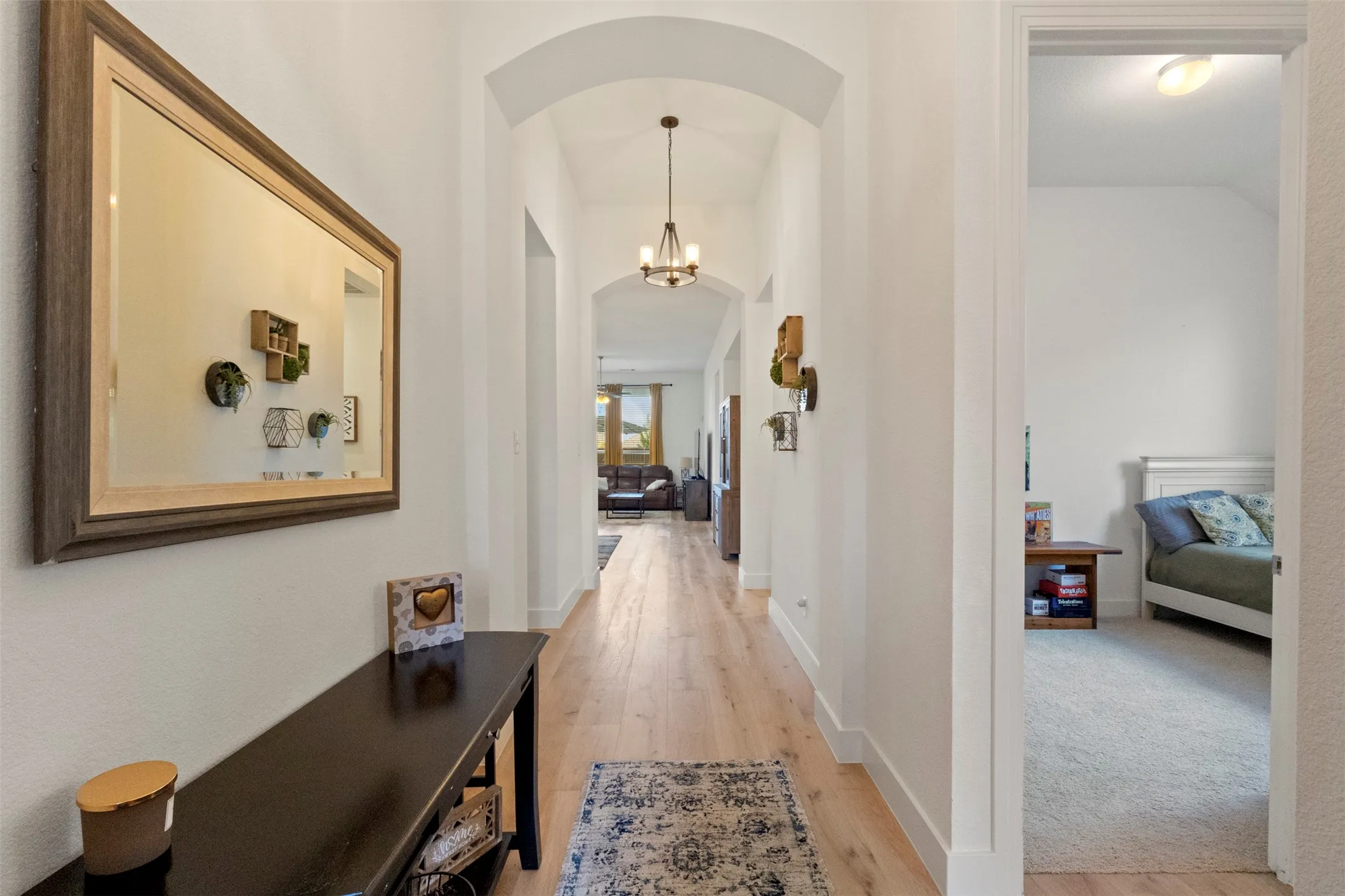 Corridor with arched walkways and light wood finished floors