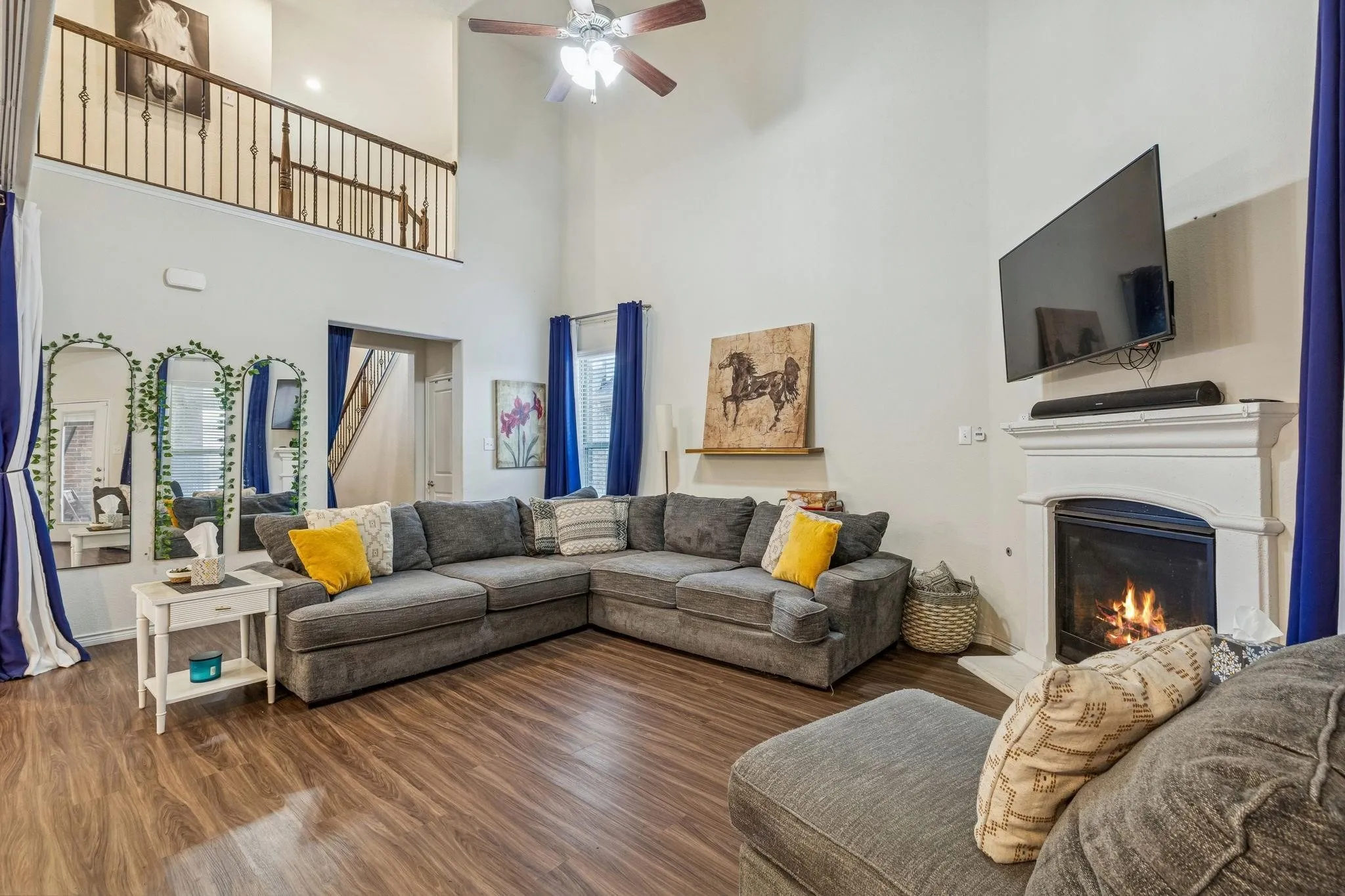 Spacious living area featuring high ceilings and wood-finish flooring
