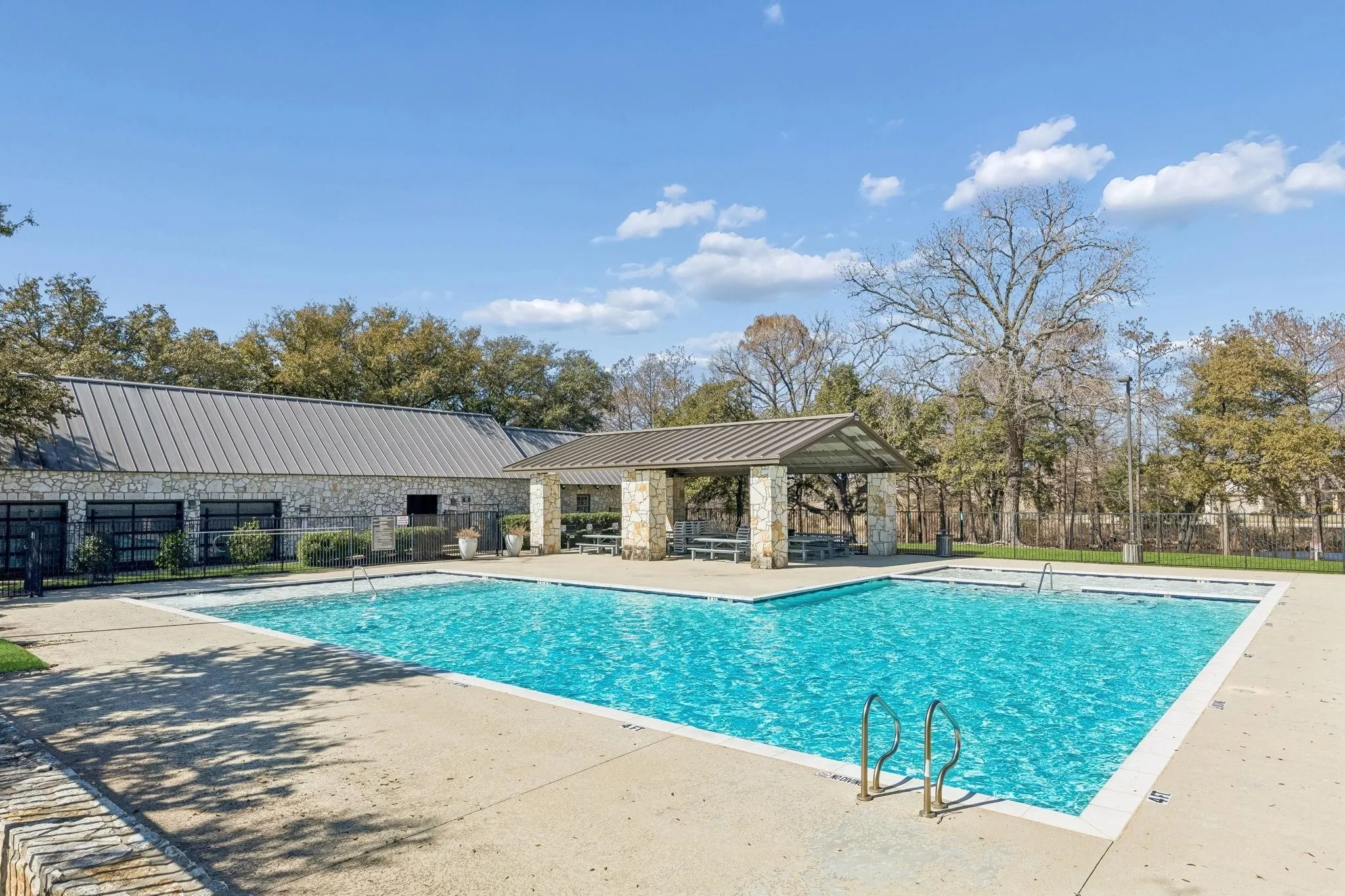 Outdoor swimming pool with integrated sun deck and expansive concrete surround