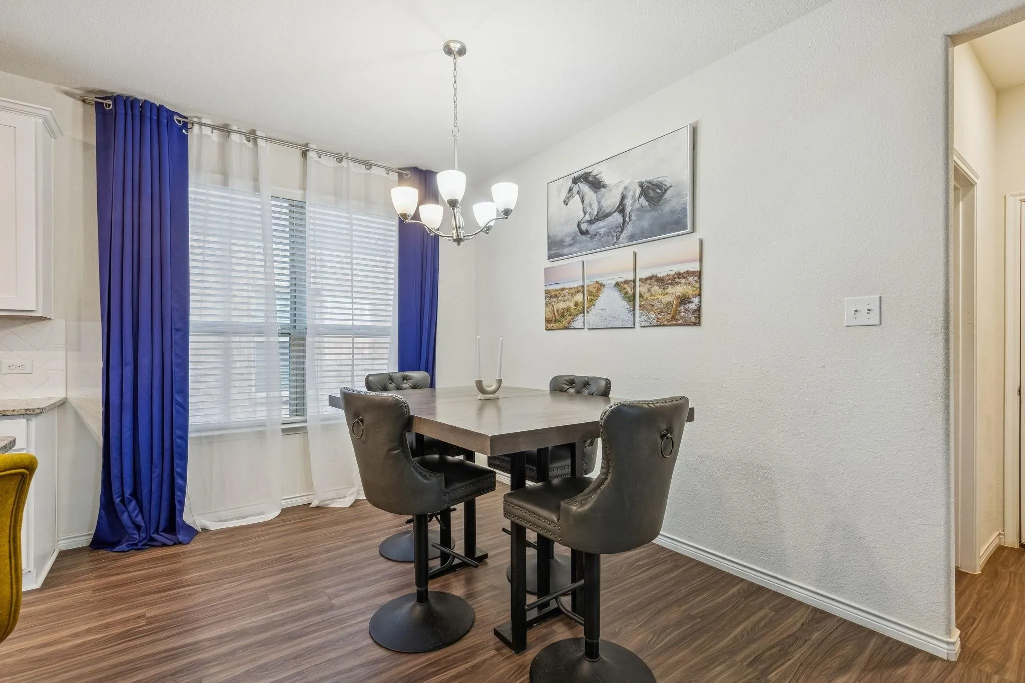 Dining area featuring wood-finish flooring, a multi-pane window with blinds, and a built-in light fixture