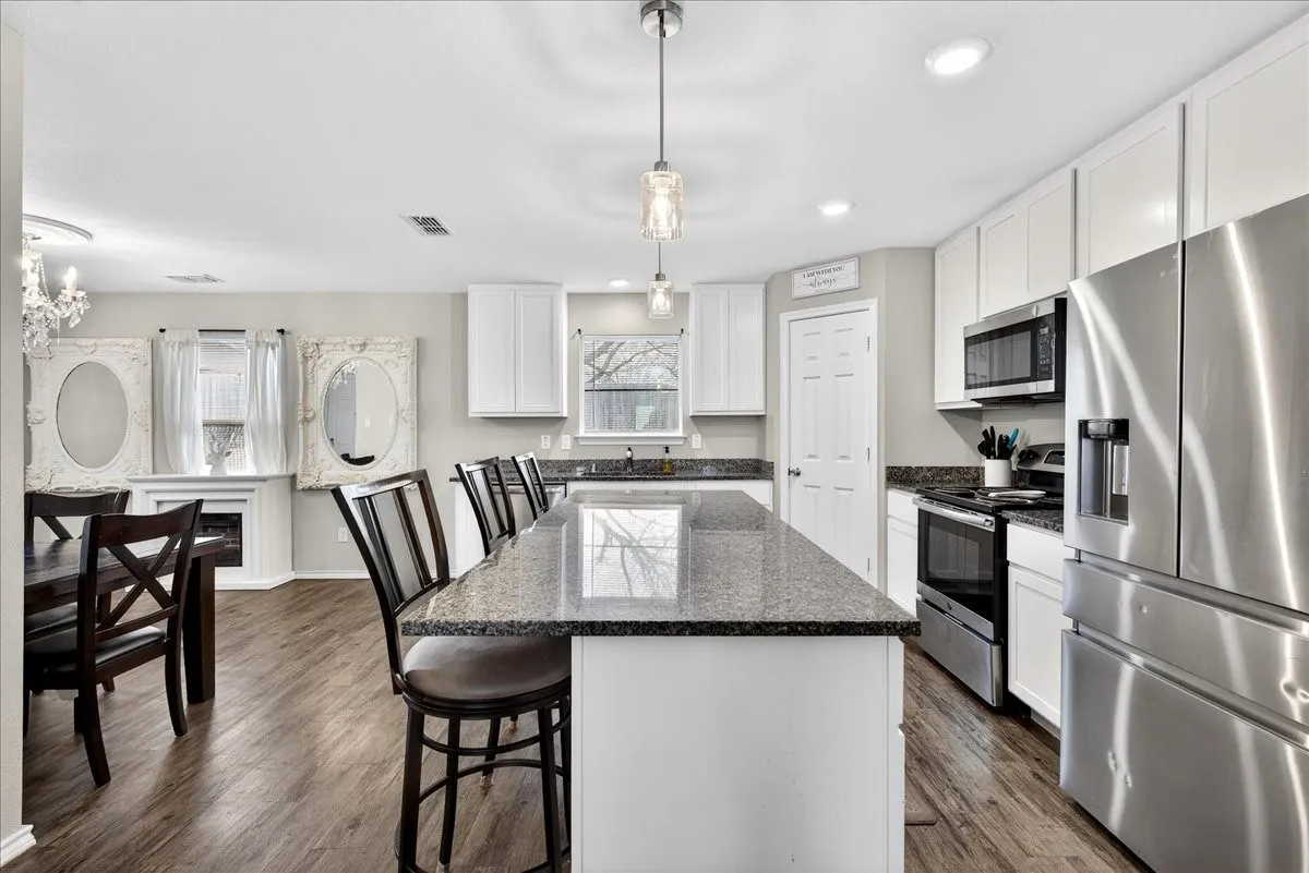 Adorable kitchen with an island, granite countertops, walk in pantry and stainless style appliances