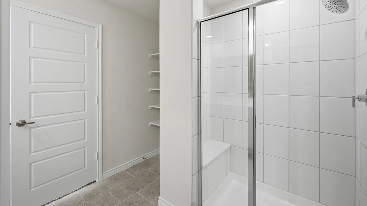 Bathroom with a shower stall and light tile patterned floors