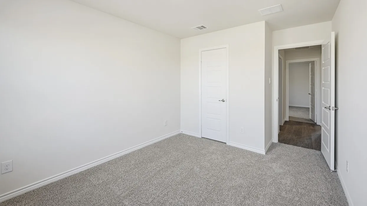 Unfurnished bedroom with light colored carpet and baseboards