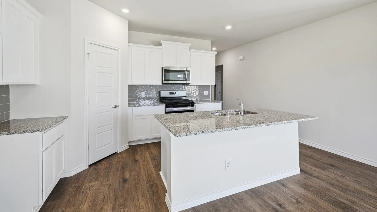 Kitchen featuring stainless steel appliances, light stone countertops, decorative backsplash, a center island with sink, and recessed lighting