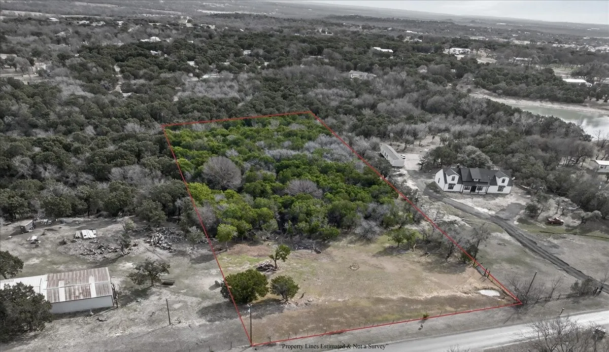 Aerial view of property's location featuring property parcel outlined and a heavily wooded area