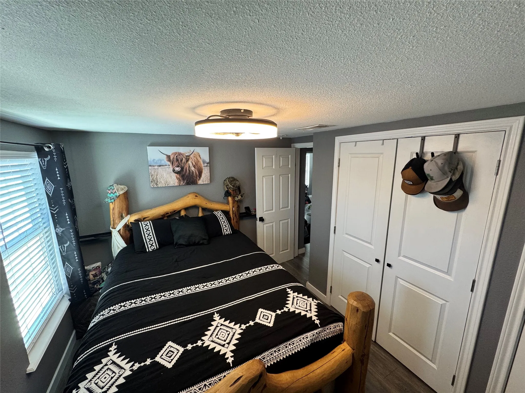 Bedroom with a stackable washer/dryer closet, and dark wood-style flooring