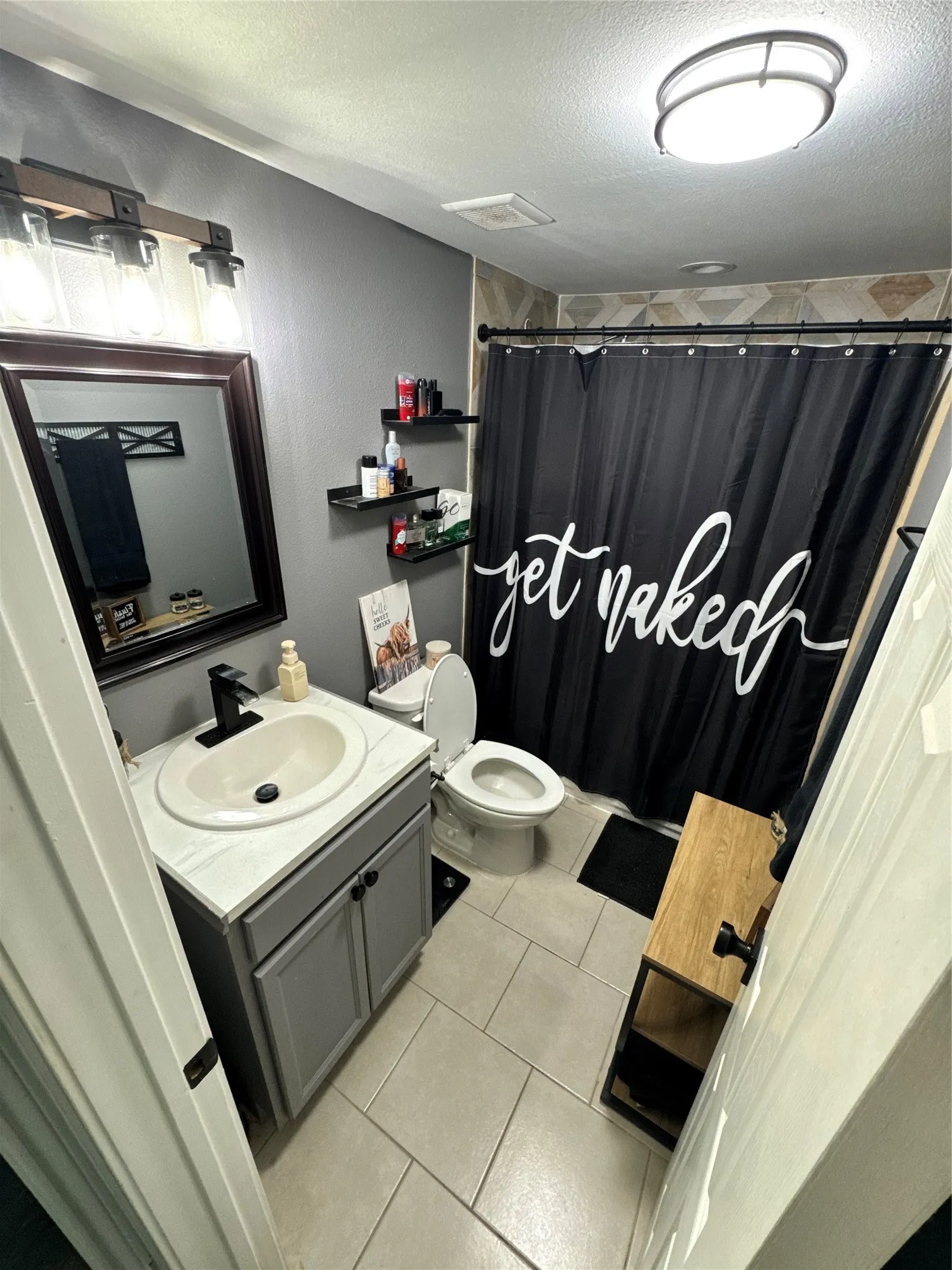Full bath with vanity and light tile patterned floors