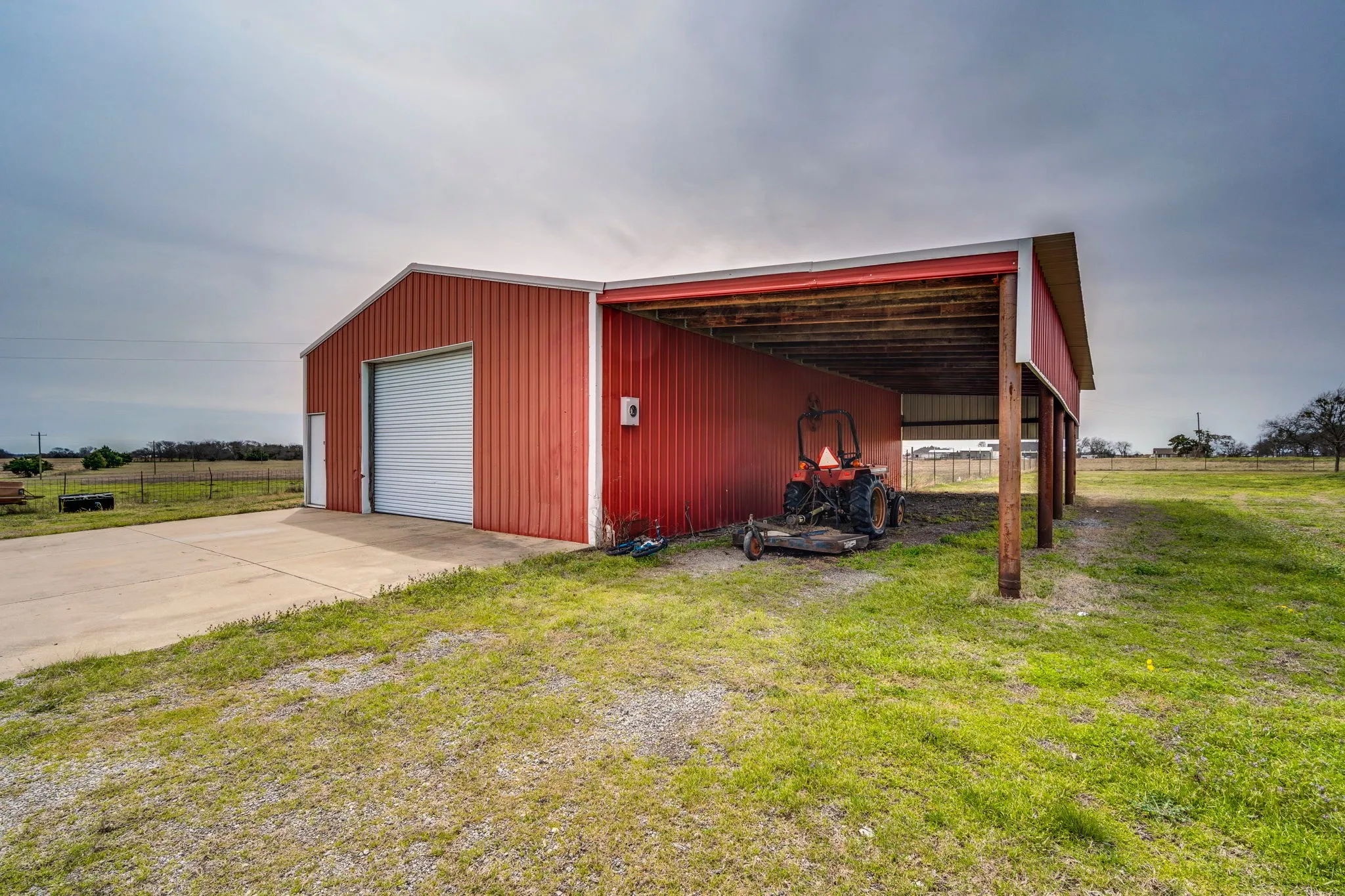 View of pole building featuring a lawn, a rural view, and driveway