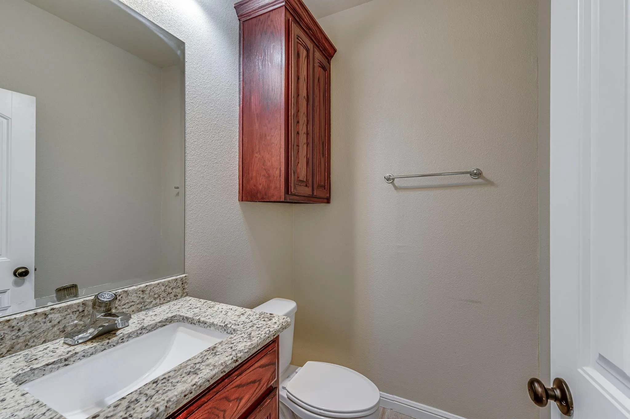 Half bath featuring vanity and a textured wall